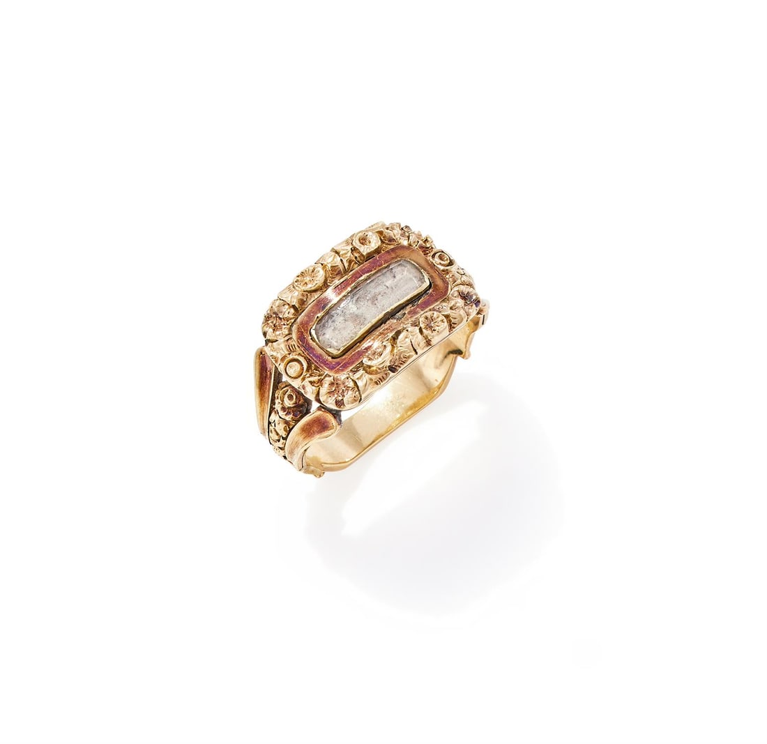 A REGENCY PANEL RING: A REGENCY PANEL RING CIRCA 1820 The rectangular panel with chased floral decoration to the border and a central locket panel within a polished surround, to trifurcated polished and floral shoulders,