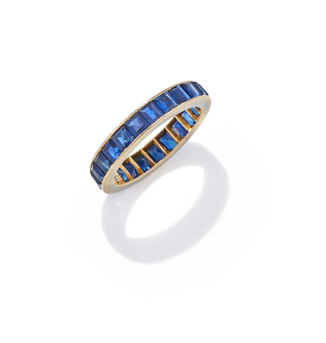 A SAPPHIRE ETERNITY RING: A SAPPHIRE ETERNITY RINGSet with a continuous row of square cut sapphires, unmarkedSize/dimensions: ring size LGross weight: 3.5 gramsProvenance: The Property of a Lady of Title