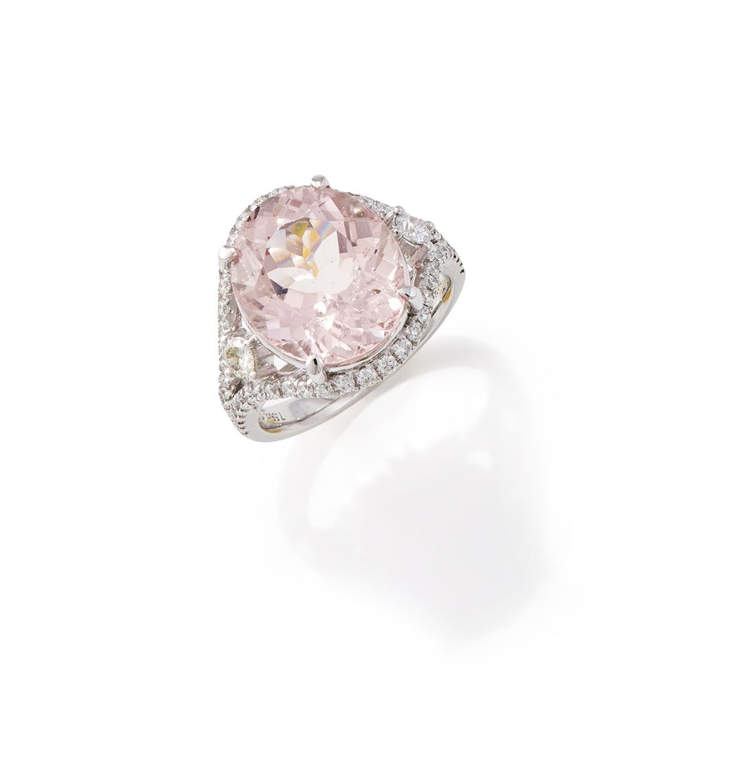 A MORGANITE AND DIAMOND DRESS RING: A MORGANITE AND DIAMOND DRESS RINGThe oval cut morganite, to a brilliant cut diamond border and bifurcated shoulders, stamped Pt950Size/dimensions: ring size NGross weight: 9.4 grams