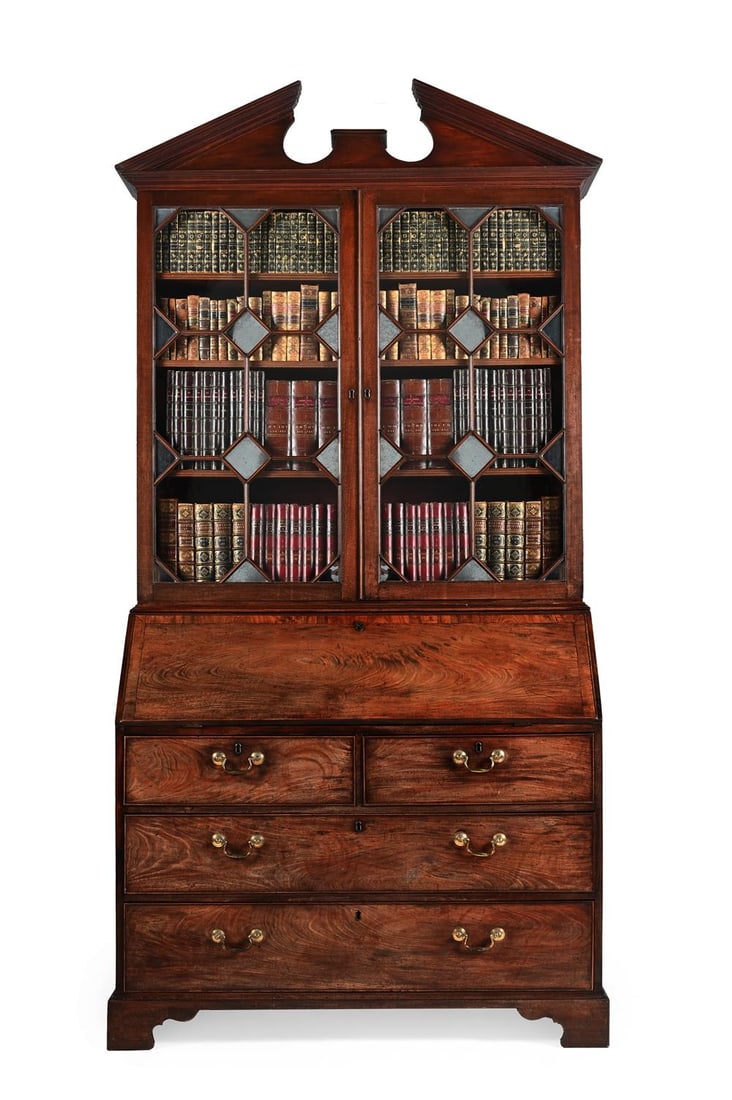 A FINE GEORGE III MAHOGANY BUREAU BOOKCASE, IN THE MANNER OF THOMAS CHIPPENDALE, CIRCA 1770: A FINE GEORGE III MAHOGANY BUREAU BOOKCASE IN THE MANNER OF THOMAS CHIPPENDALE, CIRCA 1770 The architectural cornice above a pair of geometrically glazed and mirrored panelled doors, each enclosing th