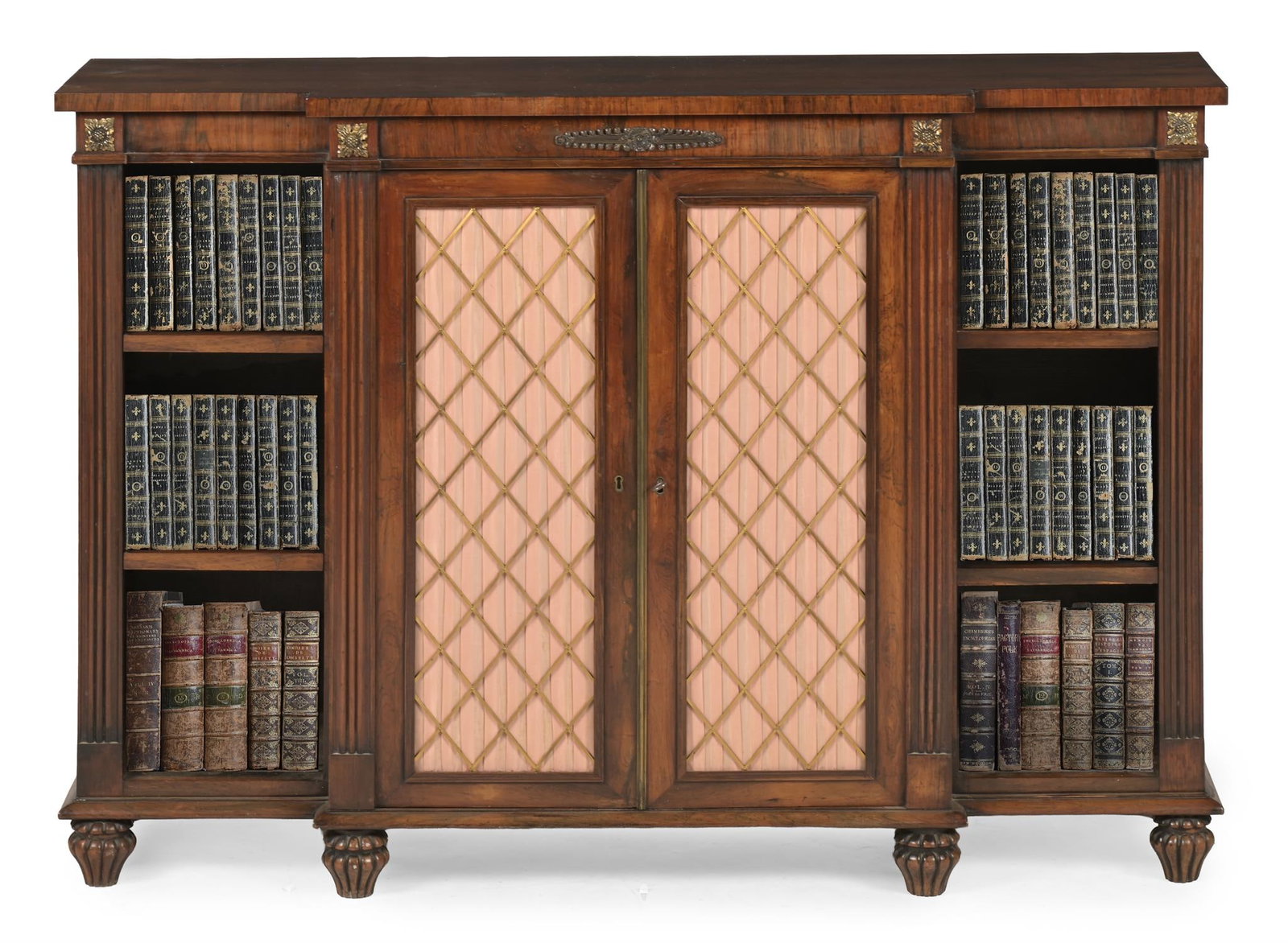 Y A REGENCY ROSEWOOD AND GILT METAL MOUNTED BREAKFRONT SIDE CABINET, CIRCA 1820: Y A REGENCY ROSEWOOD AND GILT METAL MOUNTED BREAKFRONT SIDE CABINETCIRCA 1820The brass grille and pleated silk doors opening to adjustable shelves92cm high, 128cm wide, 36.5cm deep ϒ Indicates th