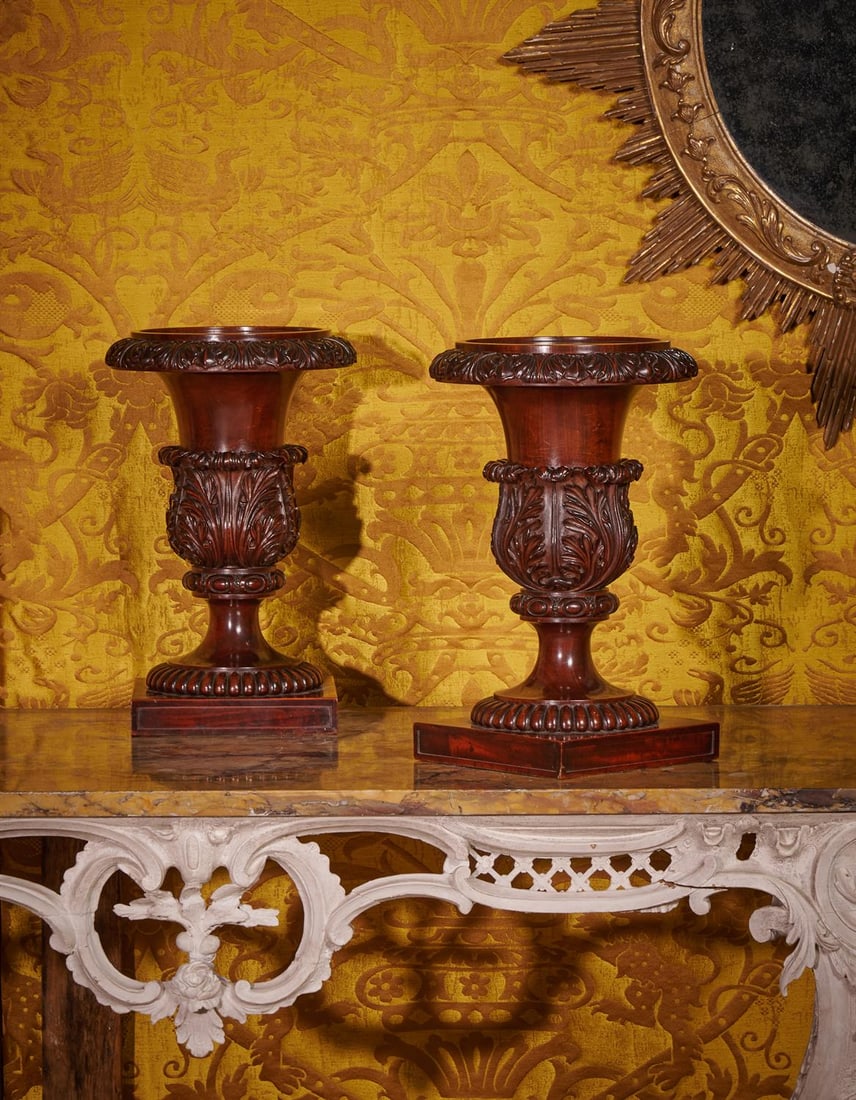 A PAIR OF REGENCY SOLID CARVED MAHOGANY VASES OR STANDS, ATTRIBUTED TO GILLOWS, CIRCA 1820: A PAIR OF REGENCY SOLID CARVED MAHOGANY VASES OR STANDS ATTRIBUTED TO GILLOWS, CIRCA 1820 Each of stylized Neoclassical Campana form and carved with foliage and alternating lotus41cm high Provenance: 
