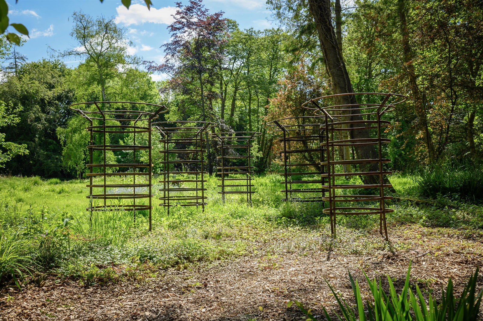 A SET OF FIVE LARGE IRON CIRCULAR TREE GUARDS, CONTEMPORARY: A SET OF FIVE LARGE IRON CIRCULAR TREE GUARDSCONTEMPORARYapproximately 185cm high, 89cm diameter, the opening 130cm diameter