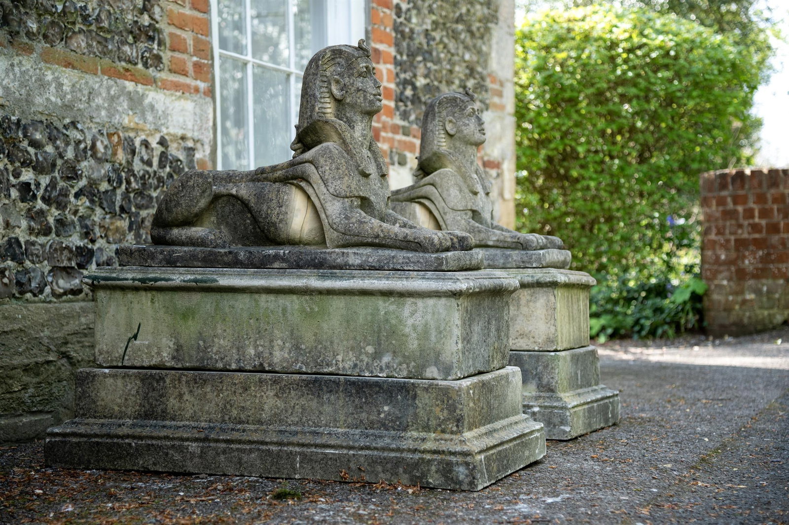 A PAIR OF COMPOSITION STONE SPHINXES, IN REGENCY STYLE, LATE 20TH CENTURY (1 of 2)