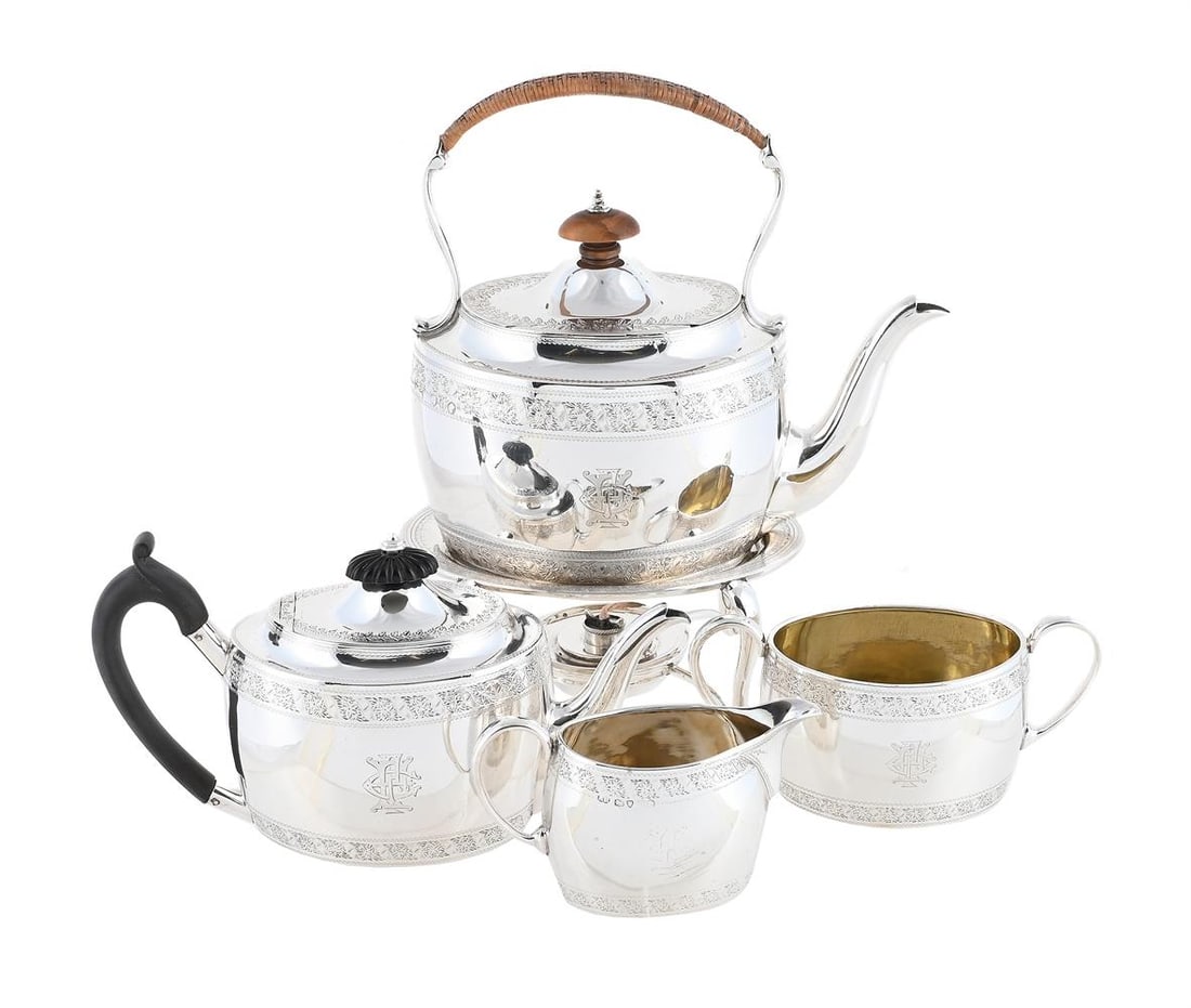 A VICTORIAN SILVER FOUR PIECE OVAL TEA SET: A VICTORIAN SILVER FOUR PIECE OVAL TEA SET HENRY HOLLAND, LONDON 1877 The kettle with a wicker wrapped loop handle, a wood oval finial to the domed cover, engraved with foliate bands and a monogram,