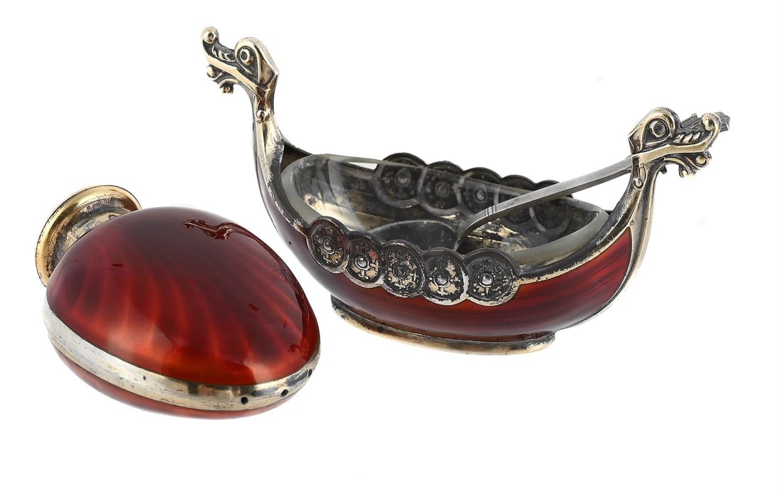 A NORWEGIAN SILVER AND ENAMEL SALT AND A PEPPERETTE: A NORWEGIAN SILVER AND ENAMEL LONGSHIP SALT THEODOR OLSENS EFTF, BERGEN, .925 STANDARD With red enamel to the body 9cm long With a clear glass liner and a salt spoon Together with: A NORWEGIAN SILVER