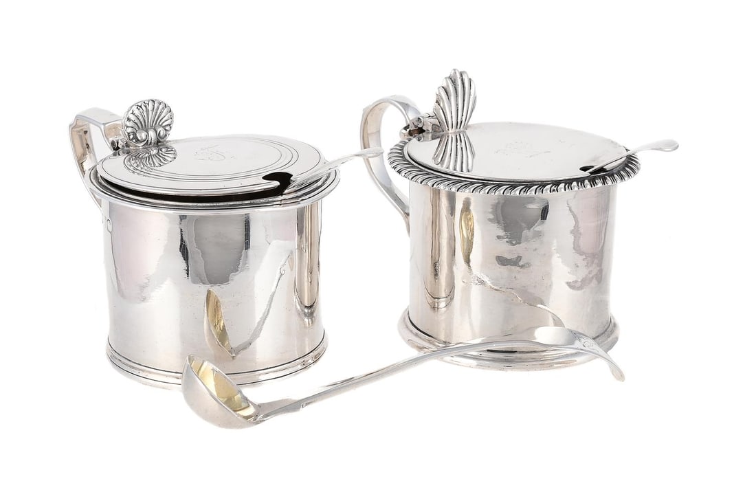 TWO SILVER MUSTARD POTS: A VICTORIAN SILVER DRUM MUSTARD JOSEPH & ALBERT SAVORY, LONDON 1840 With a shell shaped thumb piece, a scroll handle and engraved J 10cm long Together with: A SILVER DRUM MUSTARD EDWARD BARNARD