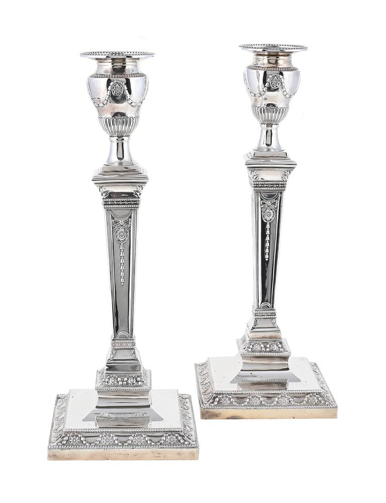A PAIR OF VICTORIAN SILVER CANDLESTICKS: A PAIR OF VICTORIAN SILVER CANDLESTICKS HAWKSWORTH, EYRE & CO. LTD., SHEFFIELD 1895 With beaded circular sconces, urn shaped capitals, tapering stems to beaded square bases, chased with husk and