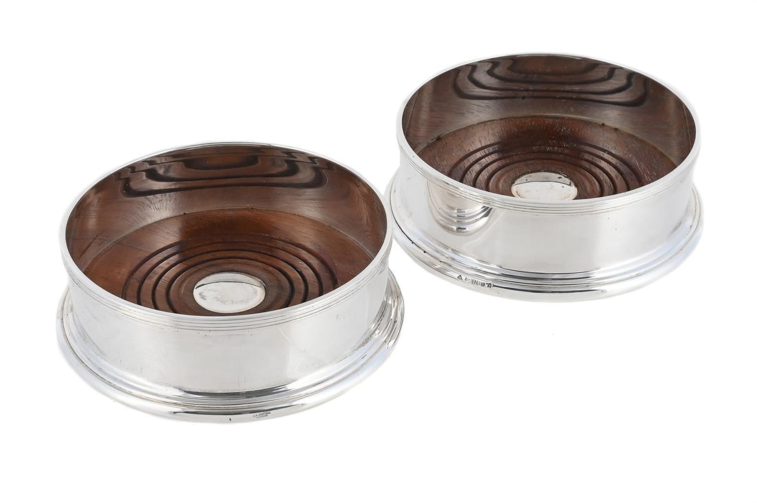 A PAIR OF SCOTTISH SILVER MOUNTED WINE COASTERS: A PAIR OF SCOTTISH SILVER MOUNTED WINE COASTERS MAKER'S MARK JAC, EDINBURGH 2002 11cm diameter With turned wood bases