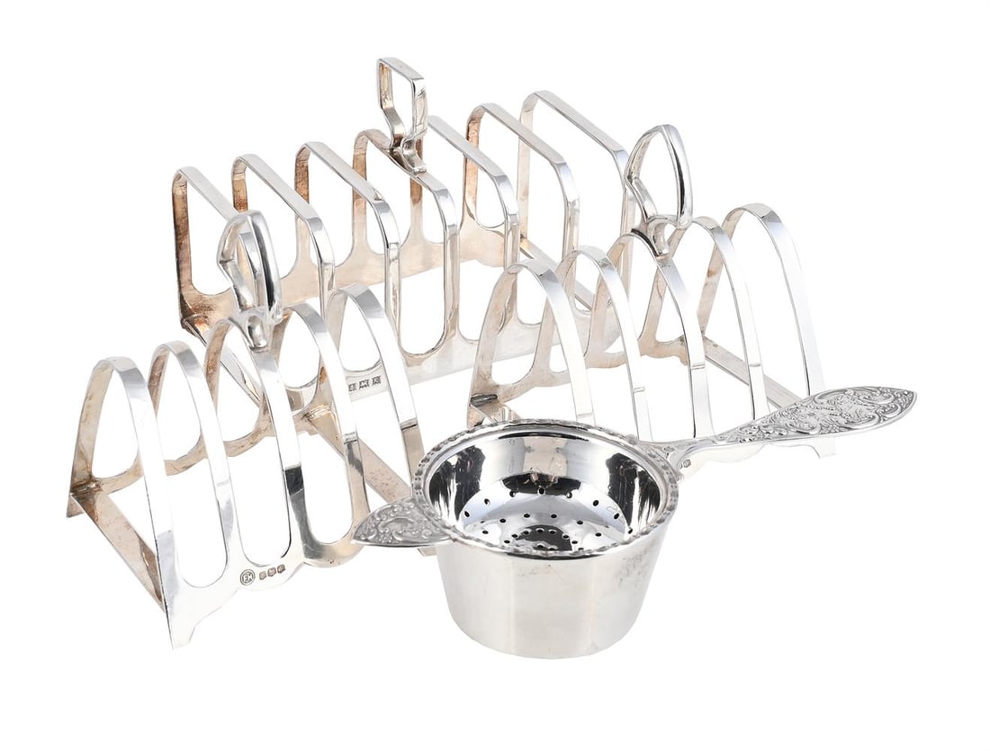 THREE SILVER TOAST RACKS AND A TEA STRAINER: A SILVER SIX DIVISION TOAST RACK ELKING