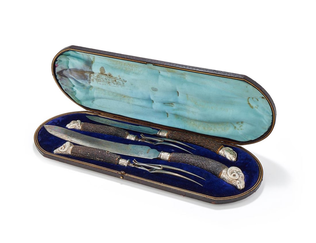 A CASED PAIR OF CARVING SETS: A CASED PAIR OF CARVING SETS HARRISON BROS & HOWSON The antler handles with plated rabbit and ram head terminals The knives 34 and 44.5cm long, the forks 28.5 and 31cm long Provenance: Private