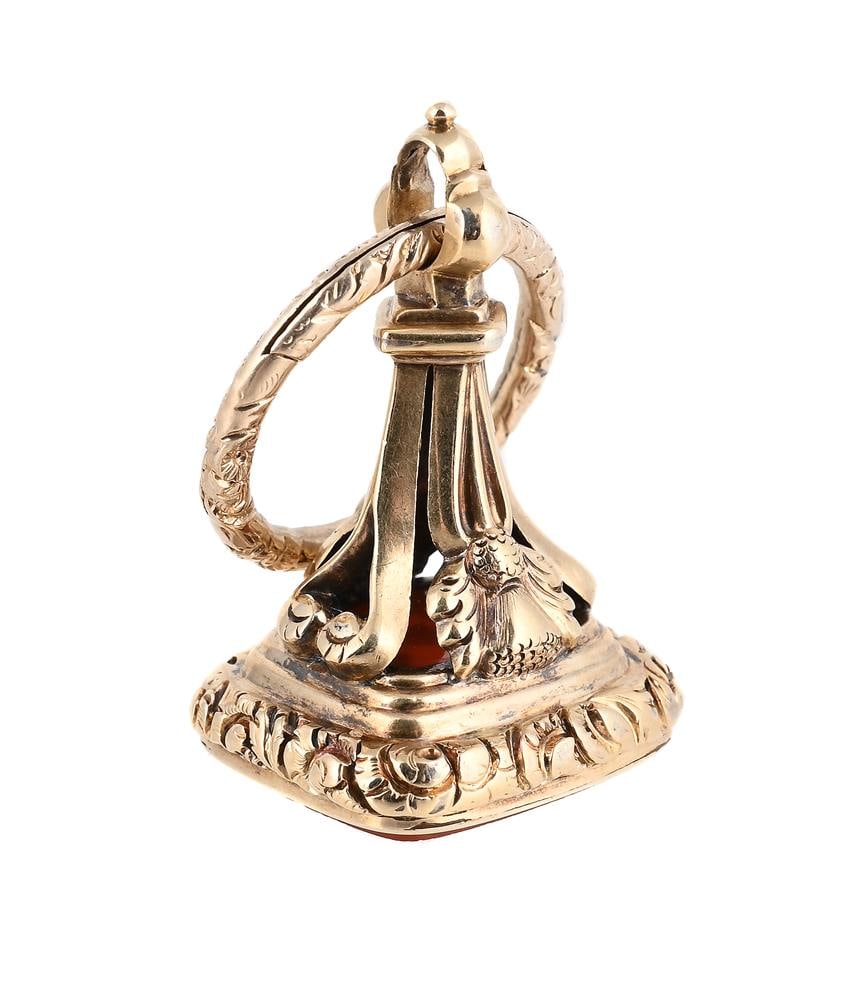 A GEORGE IV/WILLIAM IV GOLD MOUNTED CORNELIAN SEAL: A GEORGE IV/WILLIAM IV GOLD MOUNTED CORNELIAN SEAL CIRCA 1830 The cornelian intaglio engraved with a lion crest above the initial WM The mount bracket applied with thistles, suspended from a gold