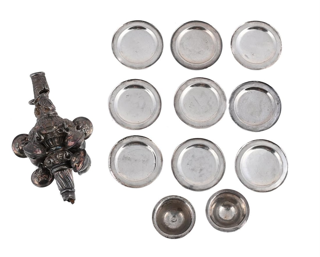 A VICTORIAN SILVER RATTLE, NINE MINIATURE PLATES AND TWO MINIATURE BOWLS: A VICTORIAN SILVER RATTLE MAKER'S MARK H. & ..., CHESTER CIRCA 1890 Chased with shells and C-scrolls, suspending nine bells 8cm long Together with: NINE MINIATURE SILVER PLATES