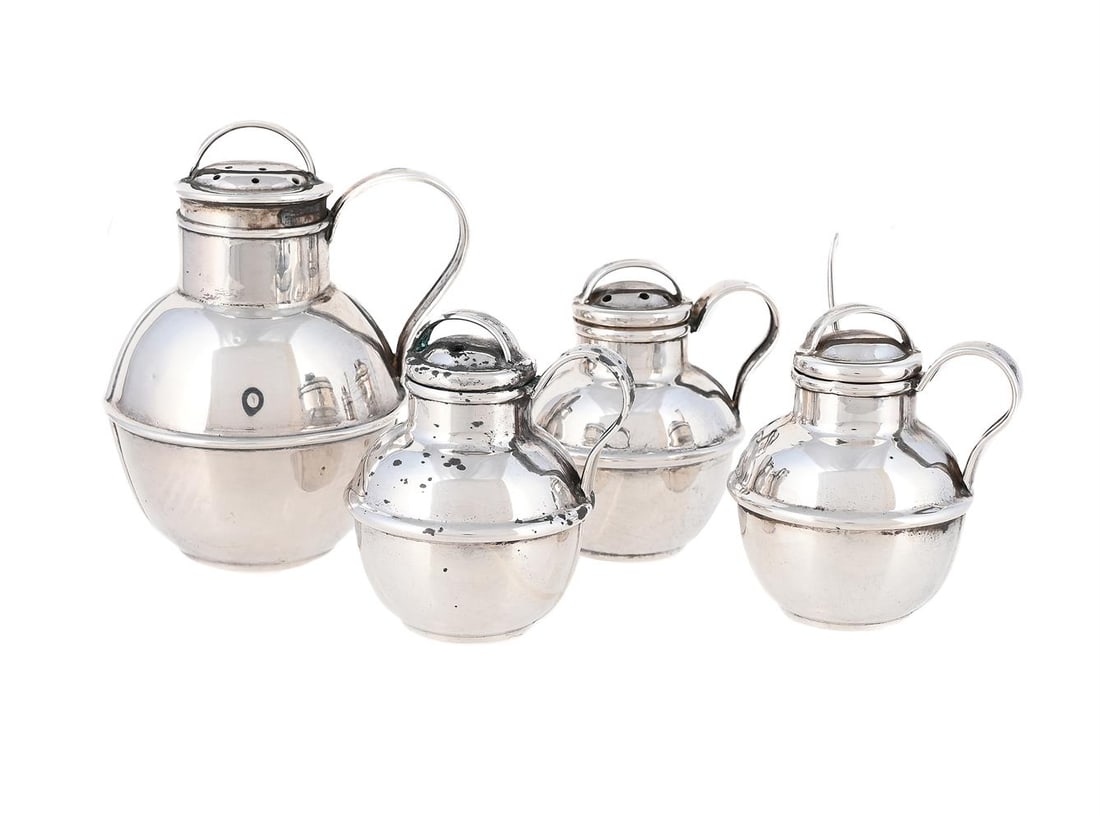 A SILVER THREE PIECE JERSEY CREAM CAN CRUET SET AND A LARGER PEPPERETTE: A SILVER THREE PIECE JERSEY CREAM CAN CRUET SET KENNETH TYLER KEY, BIRMINGHAM 1950 With loop handles to the domed covers and scroll handles to the bodies 5cm long Together with: A SILVER JERSEY CAN