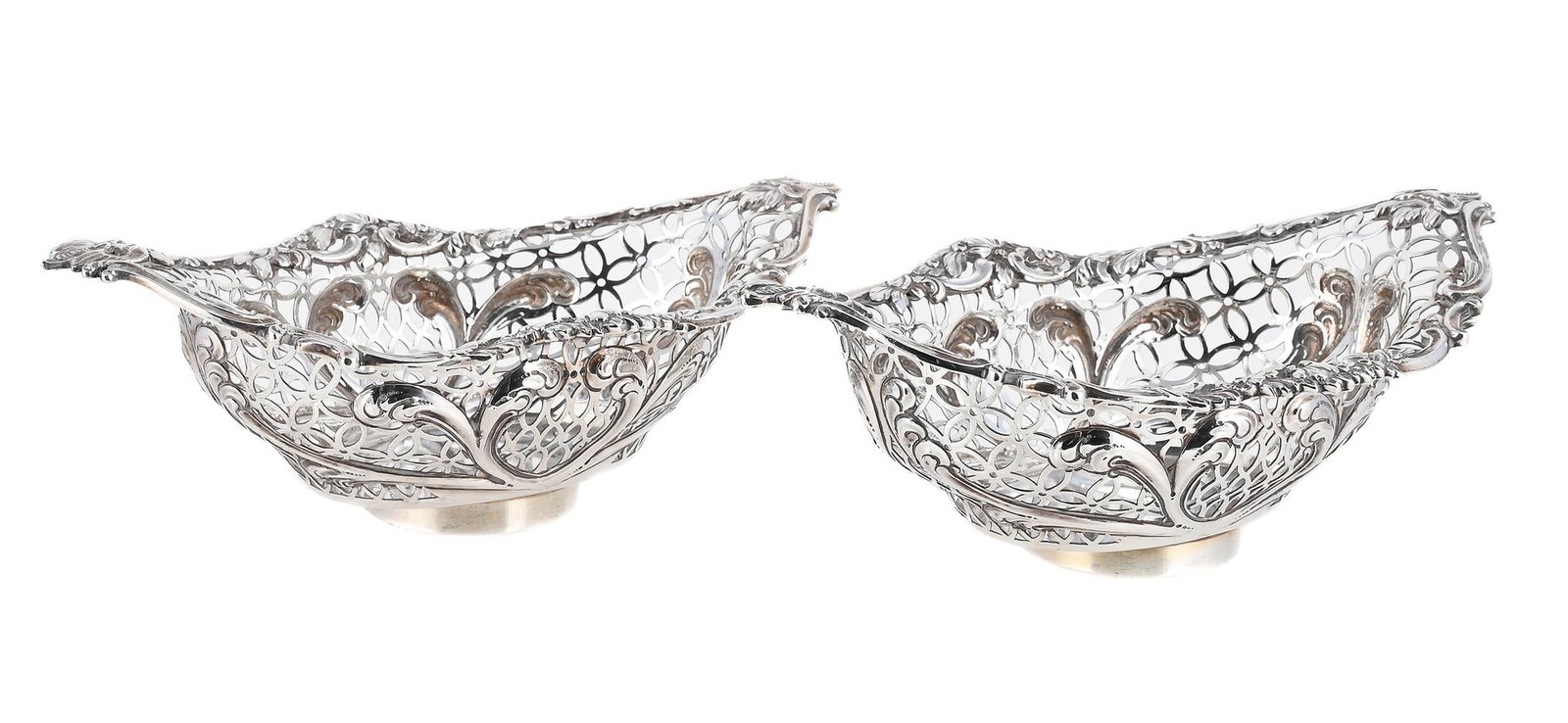 A PAIR OF VICTORIAN SILVER SHAPED OVAL BASKETS: A PAIR OF VICTORIAN SILVER SHAPED OVAL BASKETS F. B. THOMAS & CO., LONDON 1892 With chased scroll, foliate and floral borders, the bodies pierced with oval and flower head links, on circular feet