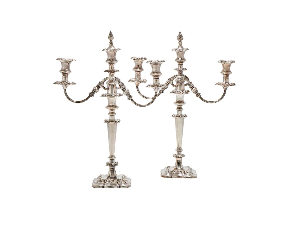 A PAIR OF SILVER PLATED THREE LIGHT CANDELABRA: A PAIR OF SILVER PLATED THREE LIGHT CANDELABRA UNMARKED With floral chased finials, shaped square sconces, waisted capitals, twin scroll arms, knopped tapering stems to shaped square bases, chased