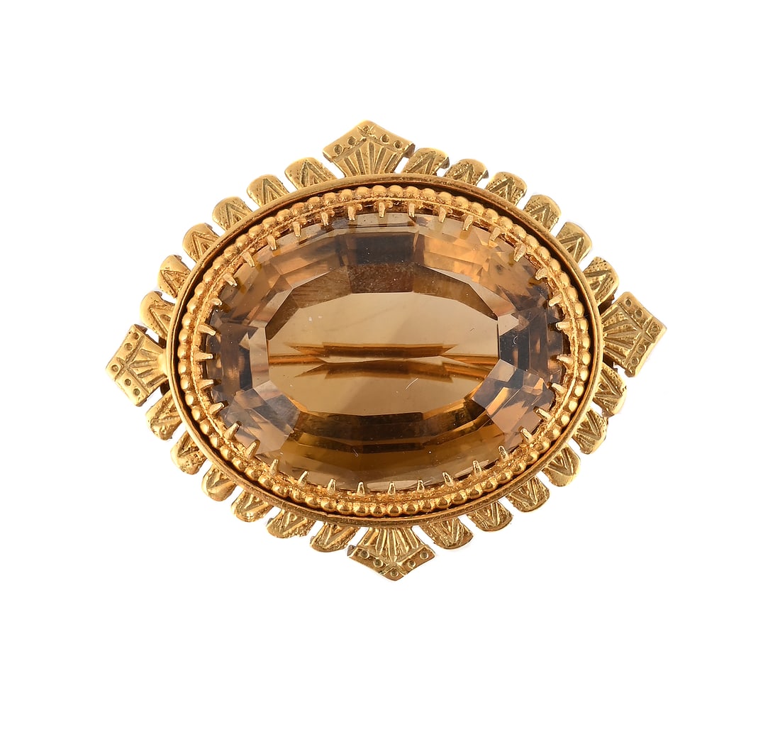 A SMOKY QUARTZ BROOCH: A SMOKY QUARTZ BROOCH The oval cut smoky quartz within a claw setting, to a pressed lobed border, stamped 9ct Size/dimensions: 4.3cm wide Gross weight: 19.4 grams Condition Report: