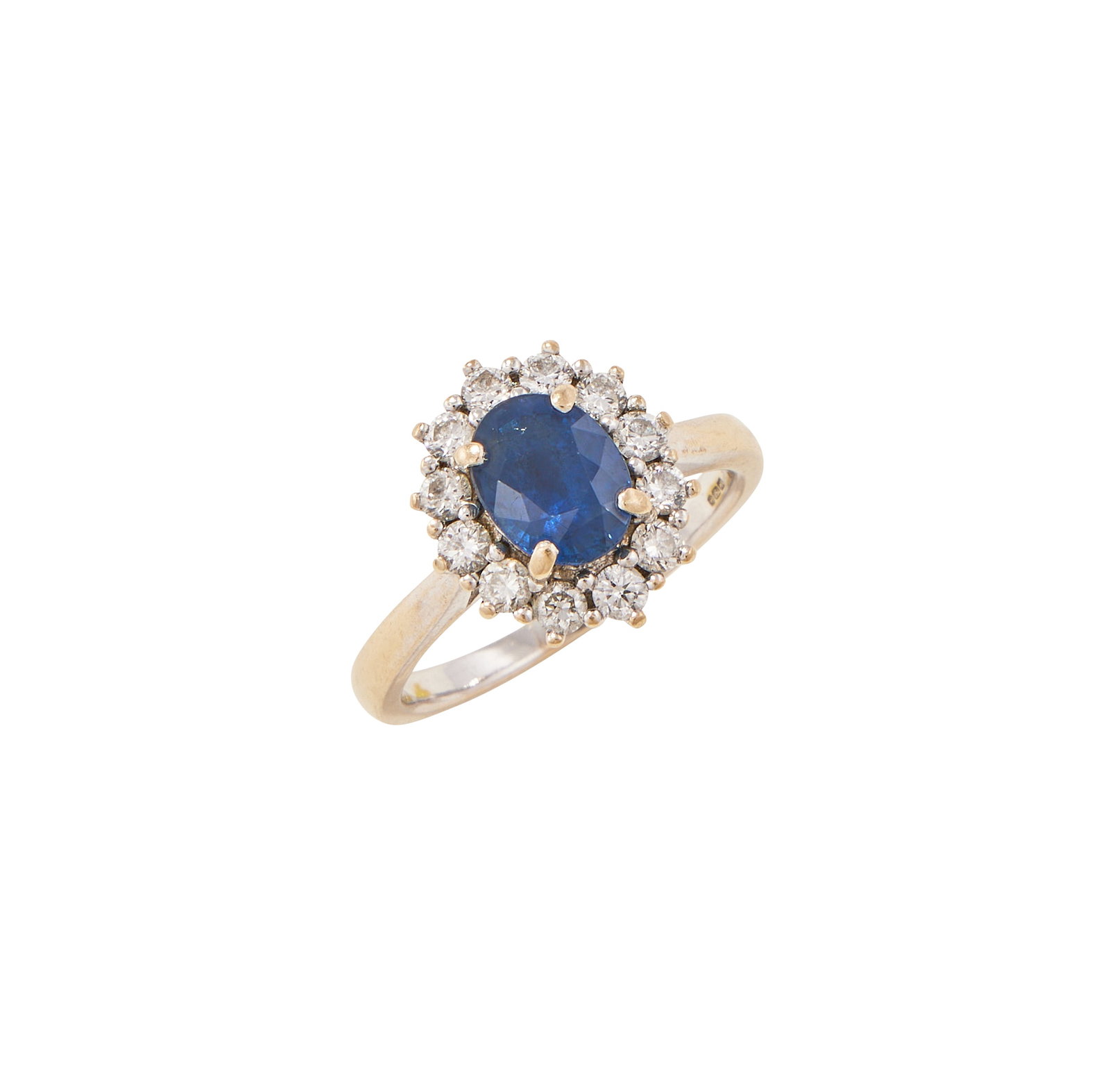 A SAPPHIRE AND DIAMOND CLUSTER RING: A SAPPHIRE AND DIAMOND CLUSTER RING The oval cut sapphire within a surround of brilliant cut diamonds, in an 18 carat gold setting, partial Birmingham hallmark Size/dimensions: ring size N½
