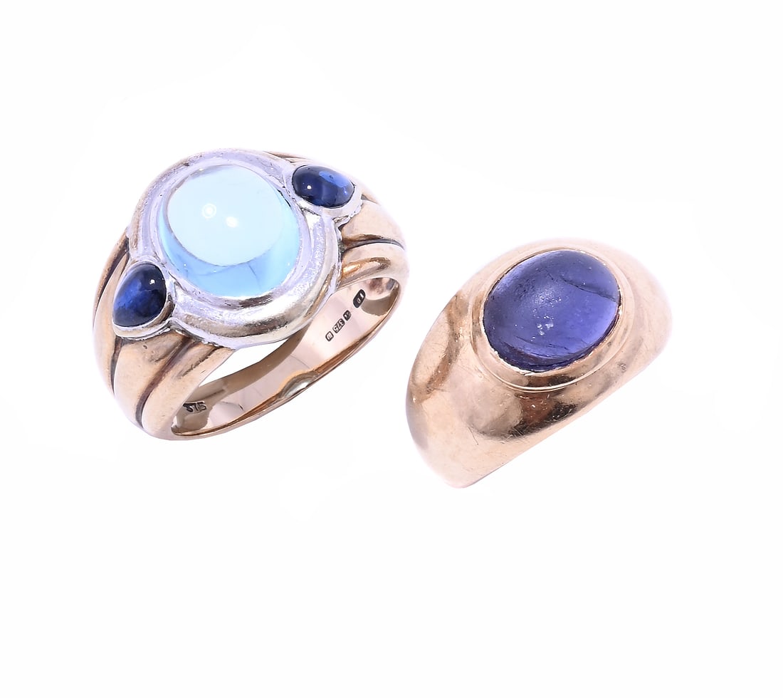 AN AQUAMARINE AND SAPPHIRE DRESS RING AND AN IOLITE DRESS RING, The oval cabochon aquamarine between: AN AQUAMARINE AND SAPPHIRE DRESS RING AND AN IOLITE DRESS RING The oval cabochon aquamarine between pear shaped cabochon sapphire shoulders, in a two colour 9 carat gold setting, London 1996