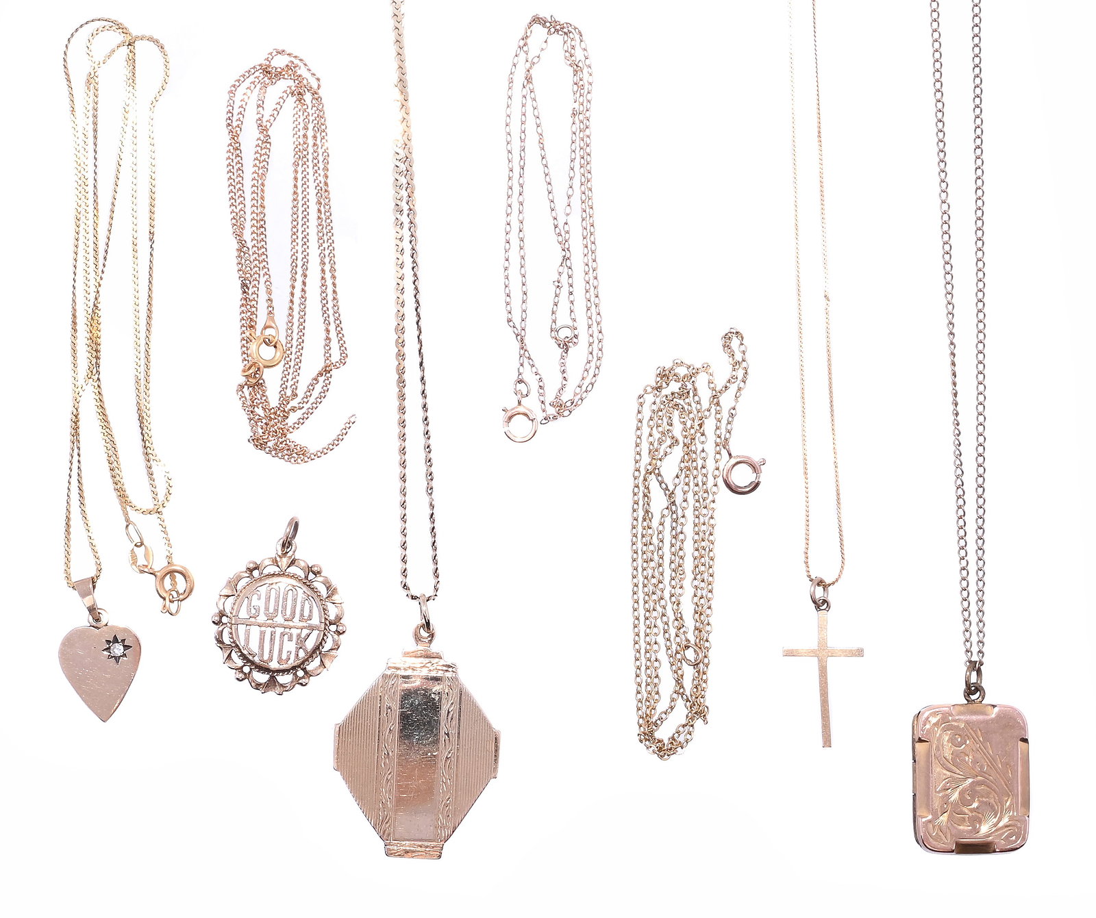 A SMALL GROUP OF PENDANTS ON CHAINS: A SMALL GROUP OF PENDANTS ON CHAINS Comprising a 9ct gold cross, London hallmark, on an associated trace link chain stamped 14k; a 9ct gold heart with diamond detail, London hallmark, on an