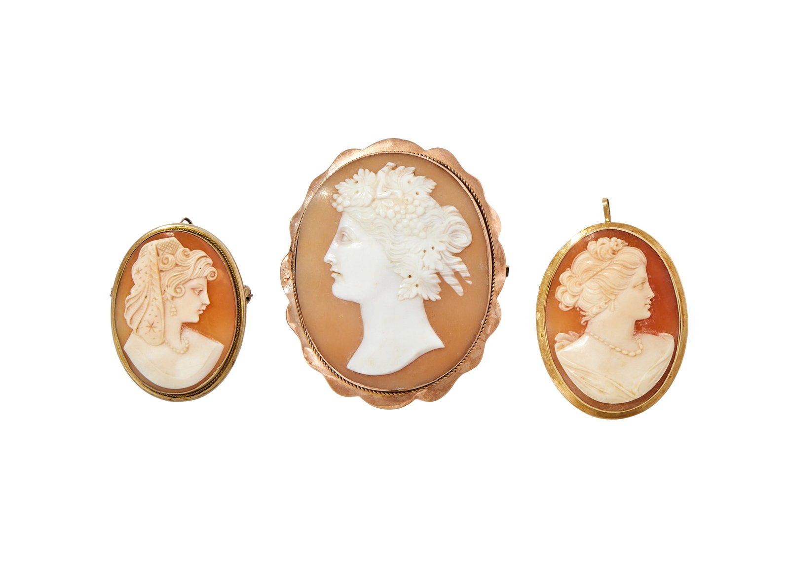 THREE SHELL CAMEO BROOCHES: THREE SHELL CAMEO BROOCHES The first a late Victorian shell cameo carved with the profile of a Bacchante, within a polished lobed setting with ropetwist detail, stamped 9ct; together with a mid 20th