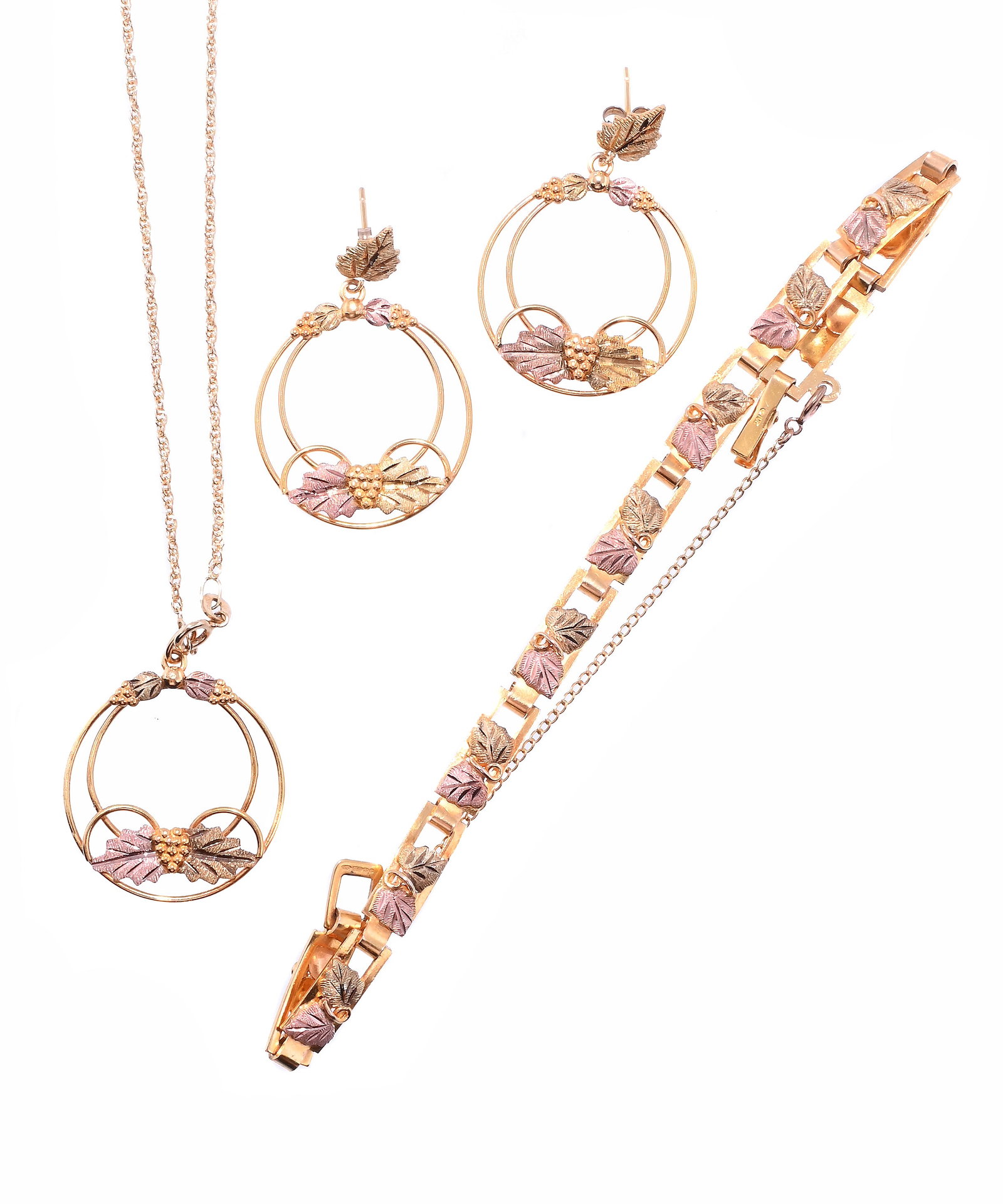 A PENDANT, EARRING AND BRACELET SET: A PENDANT, EARRING AND BRACELET SET Each designed with opposing pink and green leaves between bunches of grapes, the earrings and pendant of circlet design, all stamped 10k, the