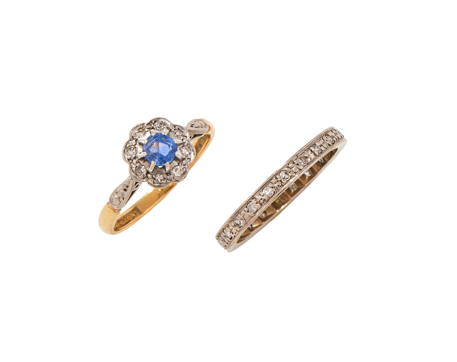 A SAPPHIRE AND DIAMOND CLUSTER RING AND A DIAMOND ETERNITY RING: A SAPPHIRE AND DIAMOND CLUSTER RING AND A DIAMOND ETERNITY RING The circular cut sapphire within a surround of single cut diamonds, signed Bravingtons, stamped 18ct & plat; the eternity