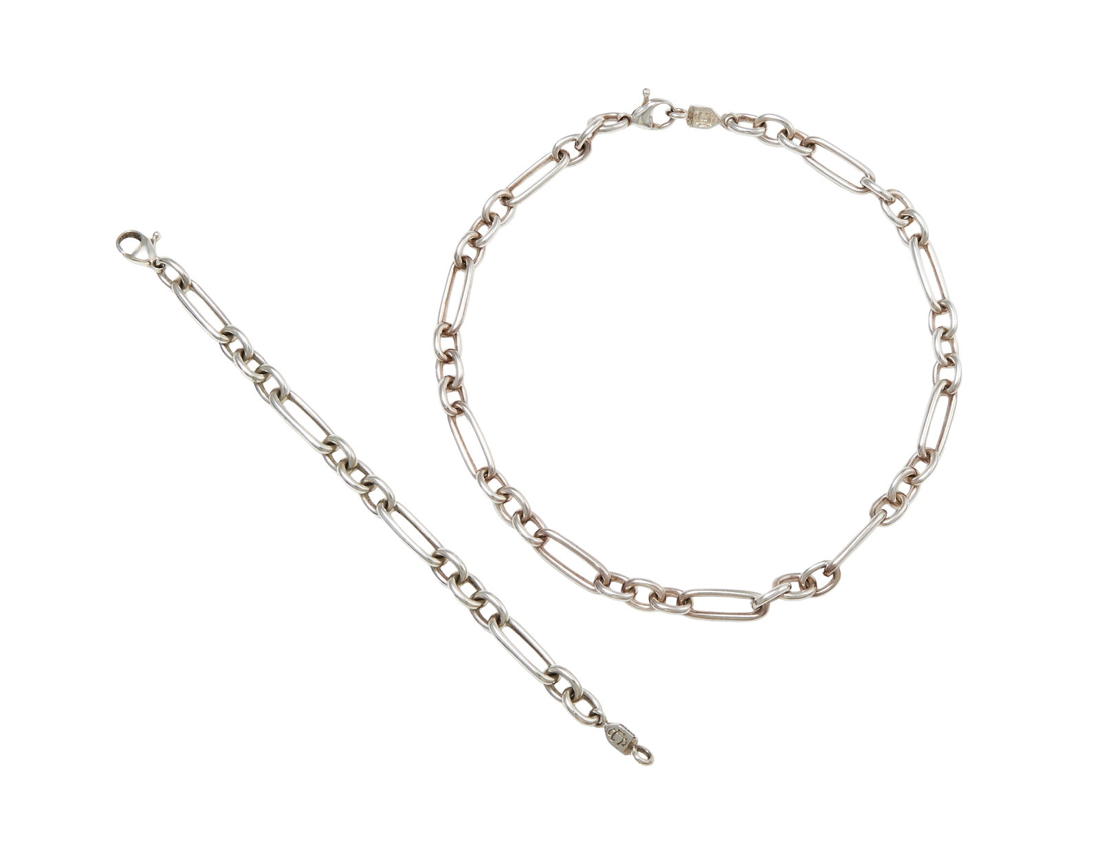 CASSANDRA GOAD, A SILVER 'BEAUMARCHAIS FIGARO' NECKLACE AND BRACELET: CASSANDRA GOAD, A SILVER 'BEAUMARCHAIS FIGARO' NECKLACE AND BRACELET LONDON 2021 AND 2022 The polished link chain with lobster claw clasp and Cassandra Goad monogram panel, the bracelet of