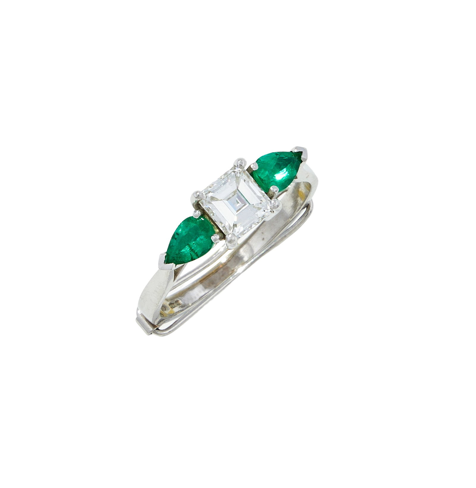 A DIAMOND AND EMERALD THREE STONE RING: A DIAMOND AND EMERALD THREE STONE RING The square cut diamond between pear shaped emerald shoulders, mounted in platinum, partial UK hallmark Size/dimensions: ring size Q (sizing band) Gross weight: