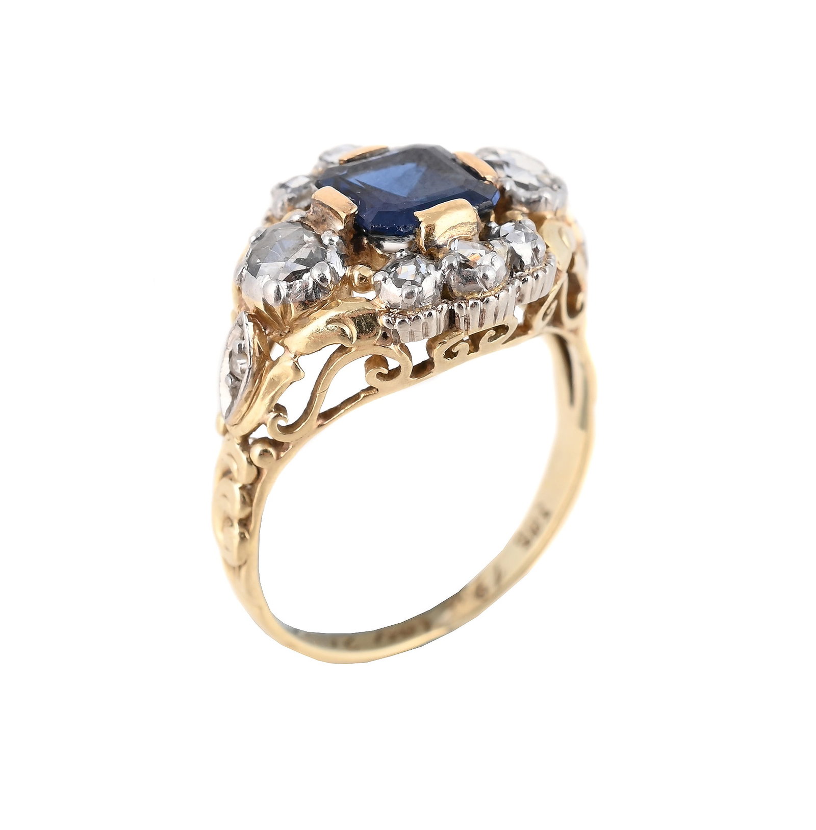 A 1960S SAPPHIRE AND DIAMOND CLUSTER RING: A 1960S SAPPHIRE AND DIAMOND CLUSTER RING The central step cut sapphire within a rose cut diamond surround, with foliate and scrolled decoration, stamped 585 with inscription 