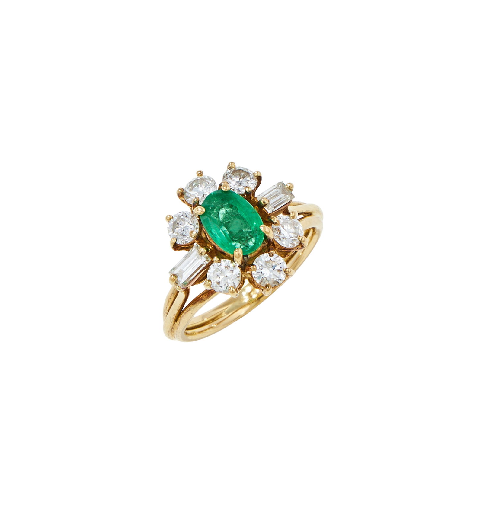 AN EMERALD AND DIAMOND CLUSTER RING: AN EMERALD AND DIAMOND CLUSTER RING The oval cut emerald within a brilliant and baguette cut diamond surround, to trifurcated shoulders, unmarked Size/dimensions: ring size L Gross weight: 5.4 grams