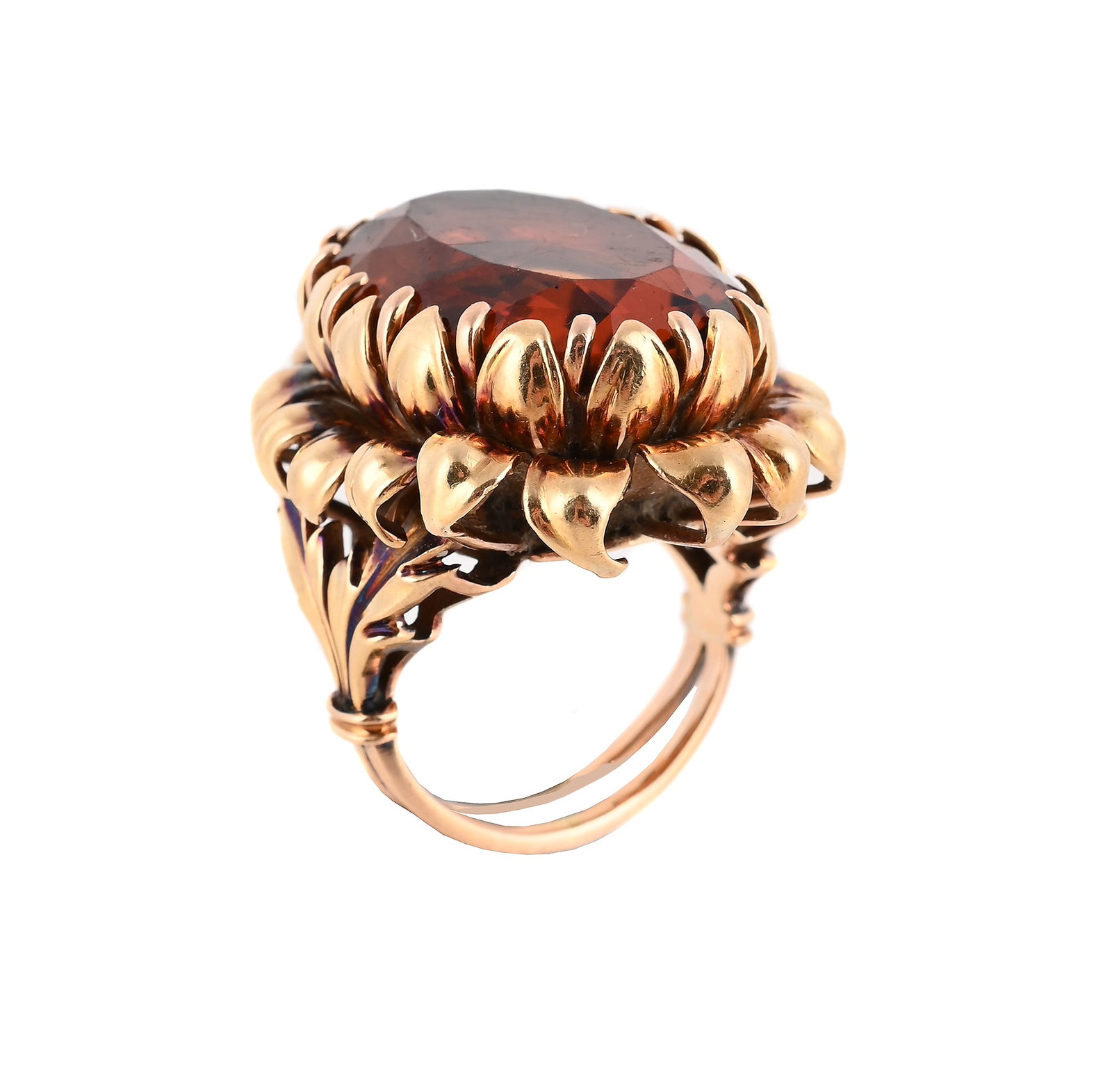 A CITRINE SET FLOWERHEAD DRESS RING: A CITRINE SET FLOWERHEAD DRESS RING MID 20TH CENTURY The oval cut citrine within a polished petal surround, to bifurcated foliate shoulders, unmarked Size/dimensions: ring size N,