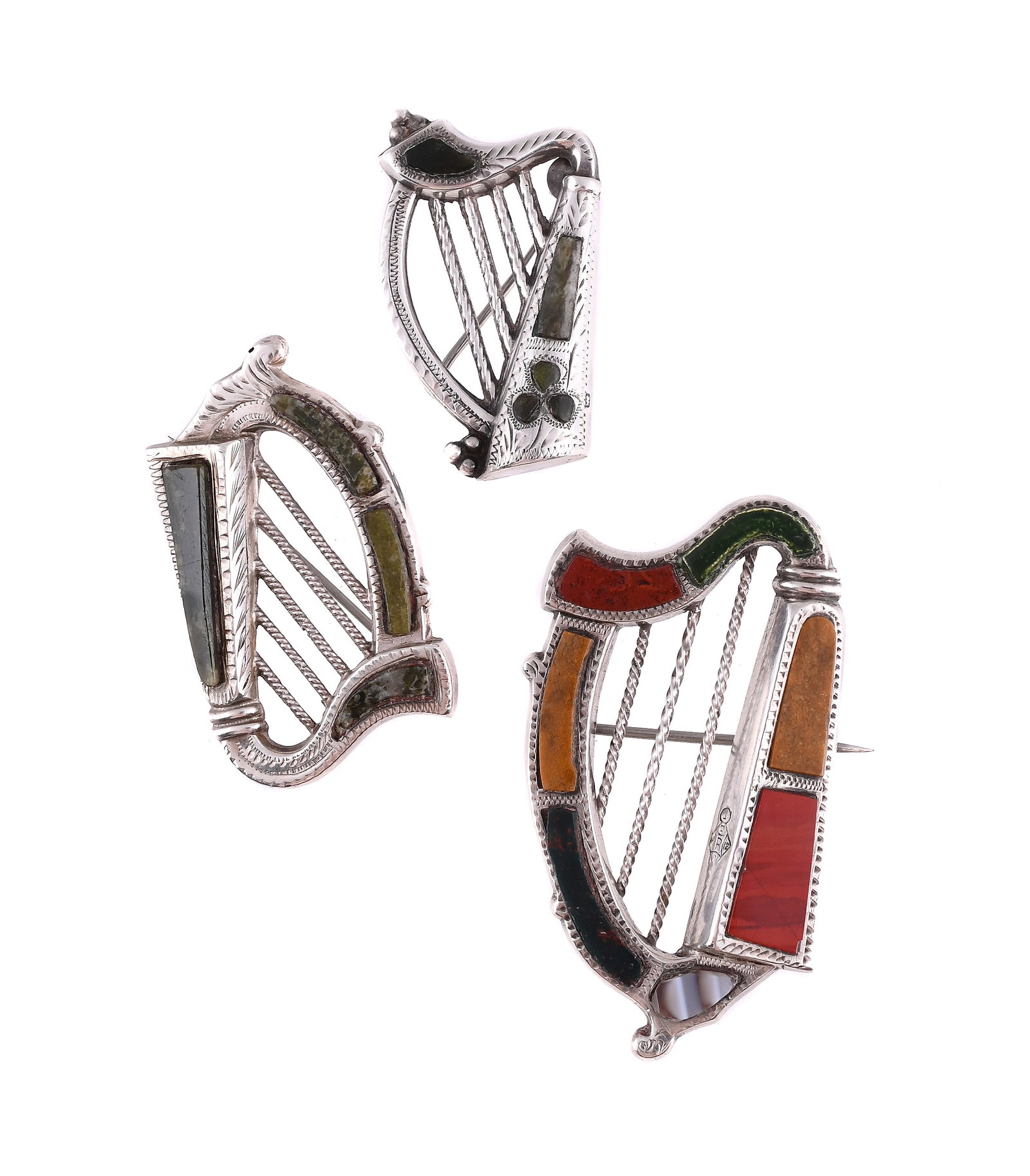 THREE ANTIQUE SILVER AND HARDSTONE HARP BROOCHES: THREE ANTIQUE SILVER AND HARDSTONE HARP BROOCHES The first with green agate and shamrock detail to the soundbox, hallmarked Birmingham 1914, maker's mark S&Co; the second with green agate