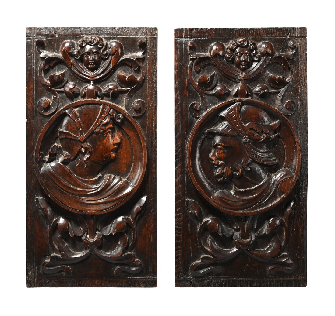 A PAIR OF CARVED OAK 'ROMAYNE' PANELS, 16TH CENTURY: A PAIR OF CARVED OAK 'ROMAYNE' PANELS 16TH CENTURY Depicting a male head with an Italian style helmet, a female figure similar but plainer, each with cherub mask surmount, scrolling foliate relief bas