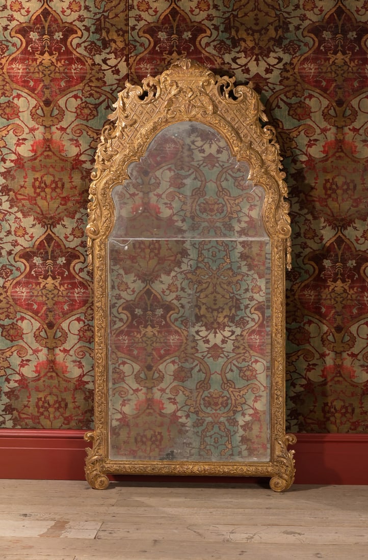 A LARGE GEORGE I CARVED GILTWOOD AND GESSO MIRROR, CIRCA 1720: A LARGE GEORGE I CARVED GILTWOOD AND GESSO MIRRORCIRCA 1720180cm high, 80cm wideProvenance:By repute, the Courtenay Family, The Earls of DevonFor a related pair of mirrors attributed to John Belchier,