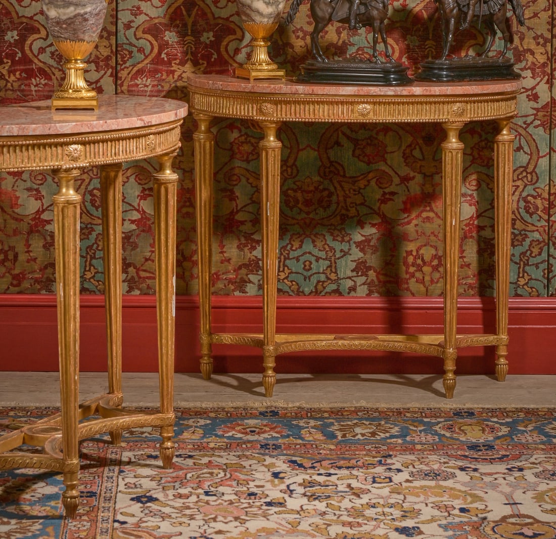 A PAIR OF GEORGE III CARVED GILTWOOD AND MARBLE TOPPED CONSOLE TABLES, CIRCA 1790: A PAIR OF GEORGE III CARVED GILTWOOD AND MARBLE TOPPED CONSOLE TABLESIN THE MANNER OF ROBERT ADAM, CIRCA 1790With fluted decoration and beaded mouldings, the frames bearing a trade label for Apter-Fre