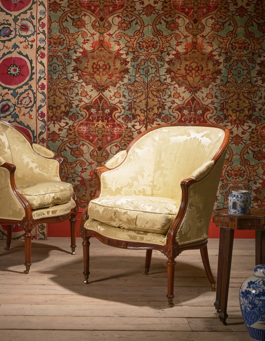 A PAIR OF GEORGE III MAHOGANY AND SILK DAMASK UPHOLSTERED BERGERE ARMCHAIRS, CIRCA 1790: A PAIR OF GEORGE IIIMAHOGANY AND SILK DAMASK UPHOLSTERED BERGERE ARMCHAIRSIN THE MANNER OF THOMAS CHIPPENDALE JUNIOR, CIRCA 179098cm high, 73cm wide, 59cm deepFor a single bergère, also in the ma