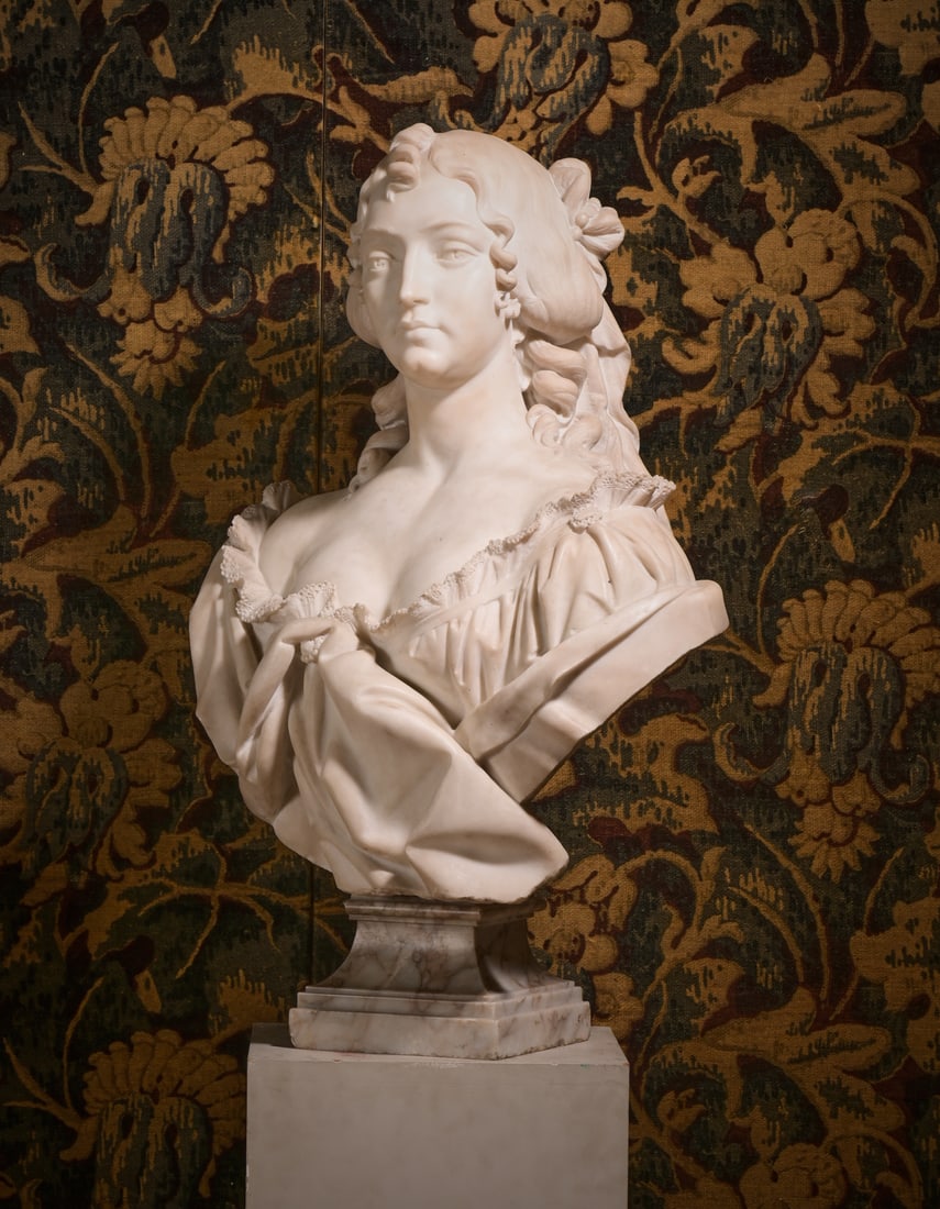 AN ITALIAN MARBLE BUST OF A YOUNG WOMAN, CIRCA 1870: AN ITALIAN MARBLE BUST OF A YOUNG WOMAN CIRCA 1870Head tilted up left, dress with tousled collar revealing upper torso and neck, on a swept square section socle base, unsigned 87cm high, 60cm wide, 38