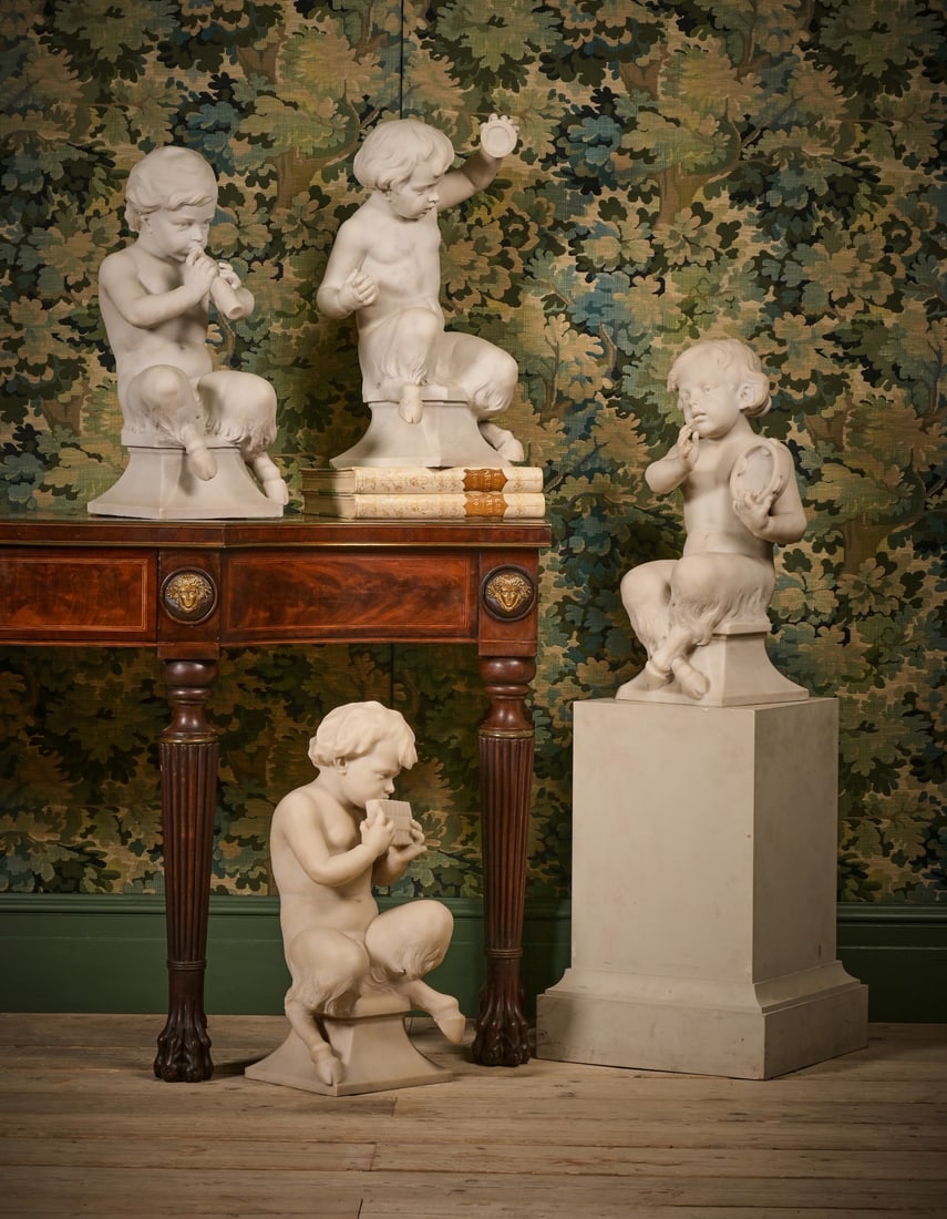 A SET OF FOUR ITALIAN CARRARA MARBLE FAUNS, LATE 19TH CENTURY: A SET OF FOUR ITALIAN CARRARA MARBLE FAUNS LATE 19TH CENTURY Each depicted with musical instruments (flute, syrinx, tambourine and clapper), in playful attitudes, seated on swept square section bases 