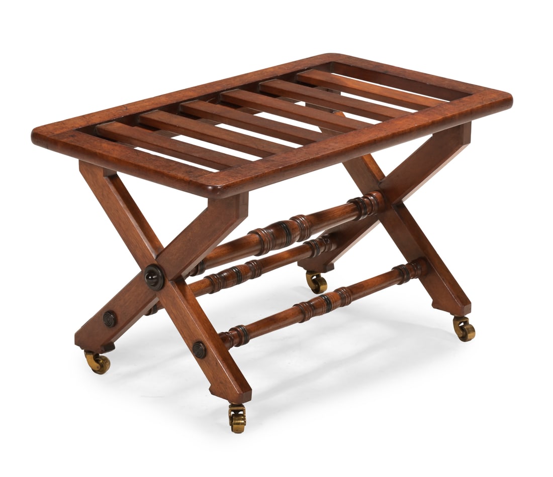A VICTORIAN WALNUT AND EBONISED X FRAME LUGGAGE STAND, LATE 19TH CENTURY: A VICTORIAN WALNUT AND EBONISED X FRAME LUGGAGE STANDLATE 19TH CENTURYThe underside of one foot stamped '3353', raised on brass castors45cm high, 76cm wide, 45.5cm deep