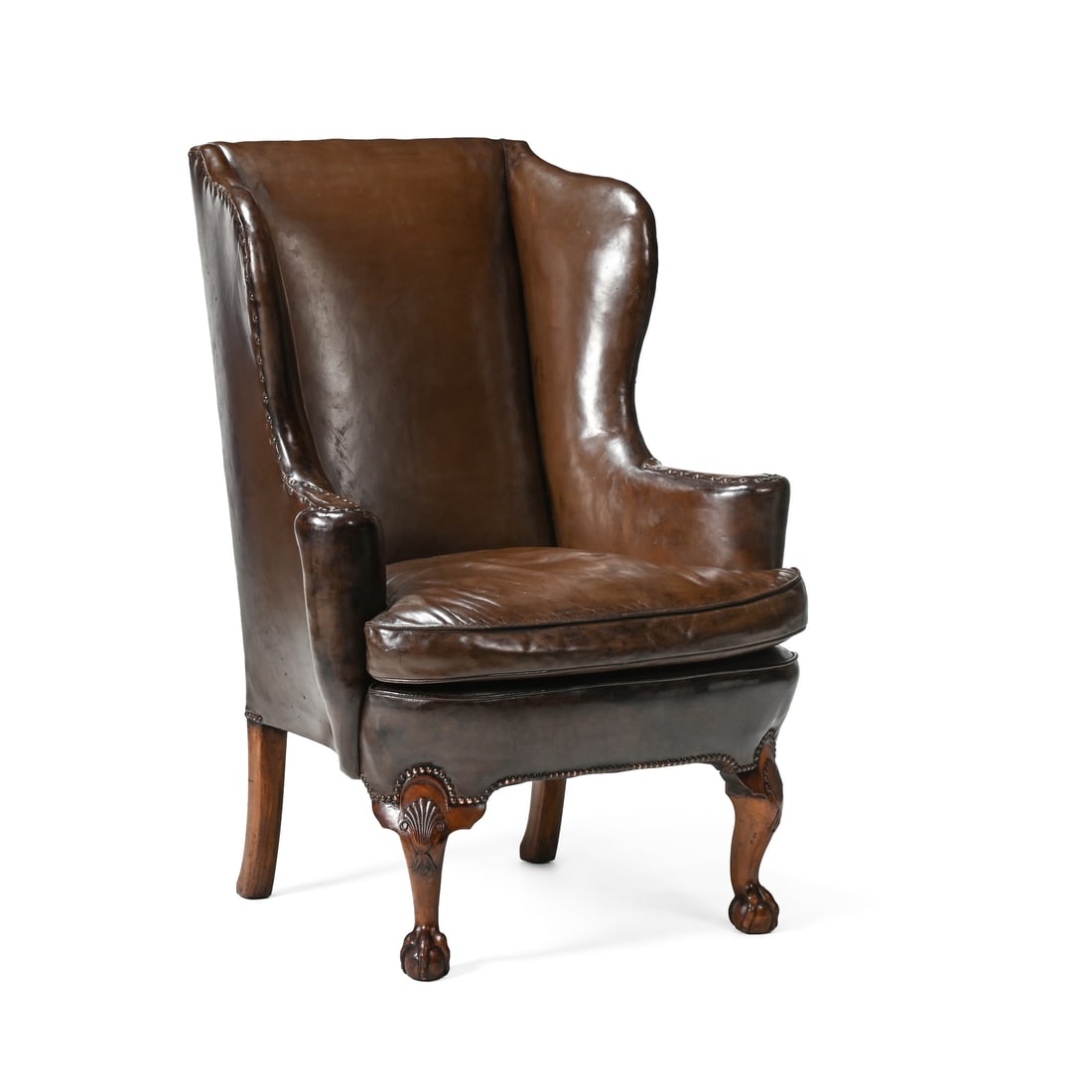 A CARVED WALNUT AND LEATHER UPHOLSTERED WING ARMCHAIR, BY HOWARD & SONS, EARLY 20TH CENTURY (1 of 4)