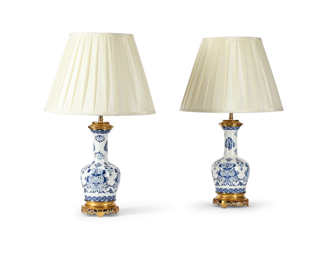 A PAIR OF FRENCH GILT MOUNTED BLUE AND WHITE PORCELAIN VASE TABLE LIGHTS, LATE 19TH CENTURY: A PAIR OF FRENCH GILTMOUNTED BLUE AND WHITE PORCELAIN VASE TABLE LIGHTS LATE 19TH CENTURY Formerly moderator lamps and now fitted for electricity and with pleated silkshades, PAT tested 29.5cm high ex