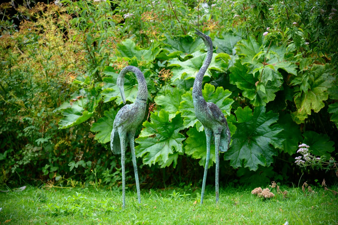 A PAIR OF JAPANESE BRONZE CRANES, 20TH CENTURY: APAIR OF JAPANESE BRONZE CRANES 20TH CENTURY the taller example 110cm high