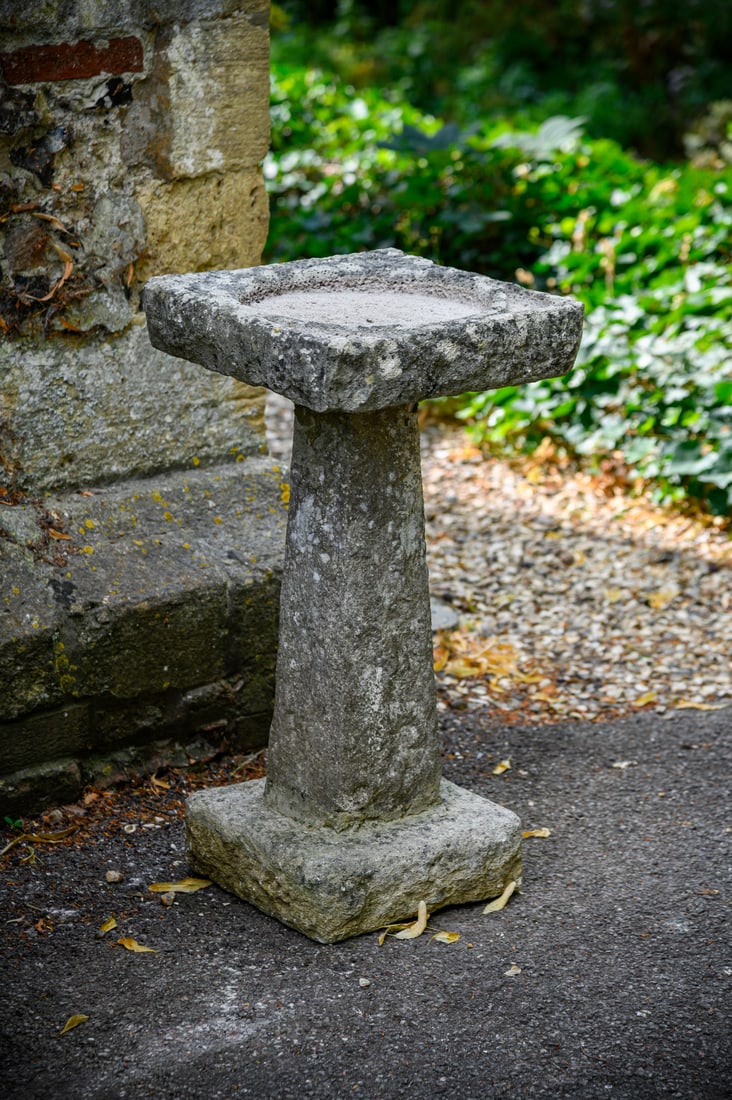A LATE GEORGE III CARVED LIMESTONE BIRDBATH, EARLY 19TH CENTURY (1 of 2)