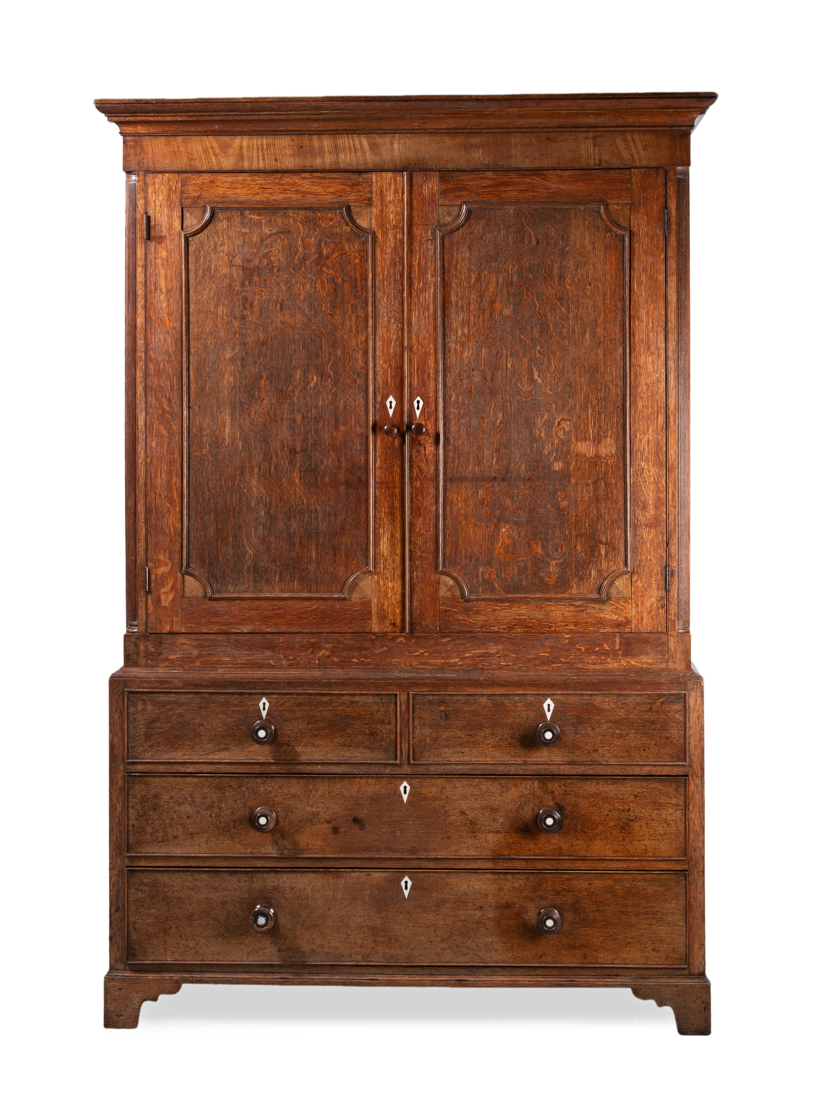 Y A GEORGE III OAK LINEN PRESS, LATE 18TH CENTURY: Y A GEORGE III OAK LINEN PRESS LATE 18TH CENTURY With two doors above two short and three long drawers, and ivory escutcheons 198cm high, 132cm wide, 52cm deep Please note Dreweatts have applied