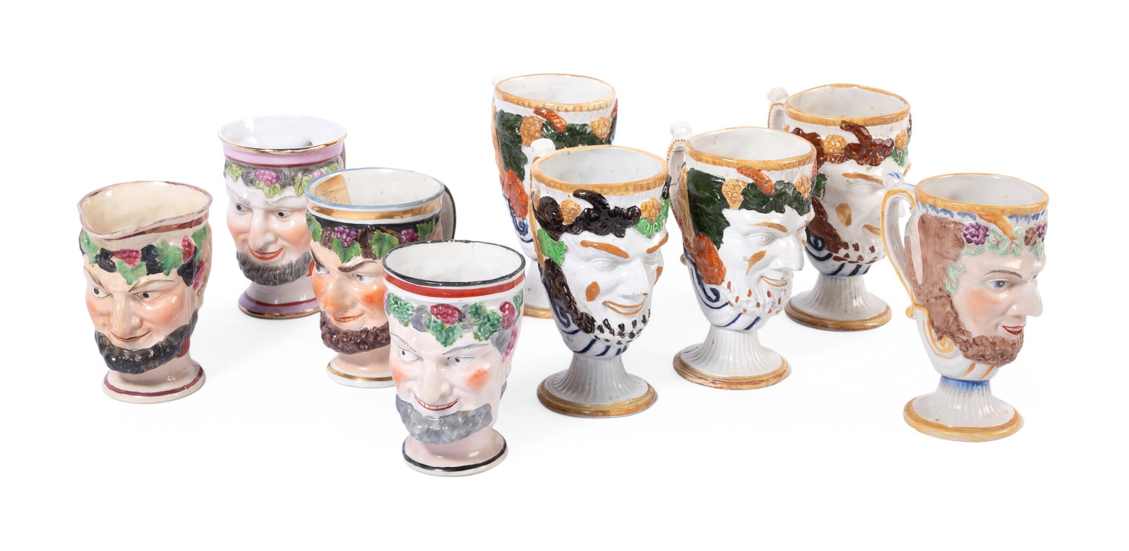 FIVE STAFFORDSHIRE POTTERY SATYR-MASK JUGS WITH FROG INSERTS, MID 19TH CENTURY: FIVE STAFFORDSHIRE POTTERY SATYR-MASK JUGS WITH FROG INSERTS MID 19TH CENTURY approximately 12.5cm high Together with four later British and German porcelain examples, approximately 10cm high (9)