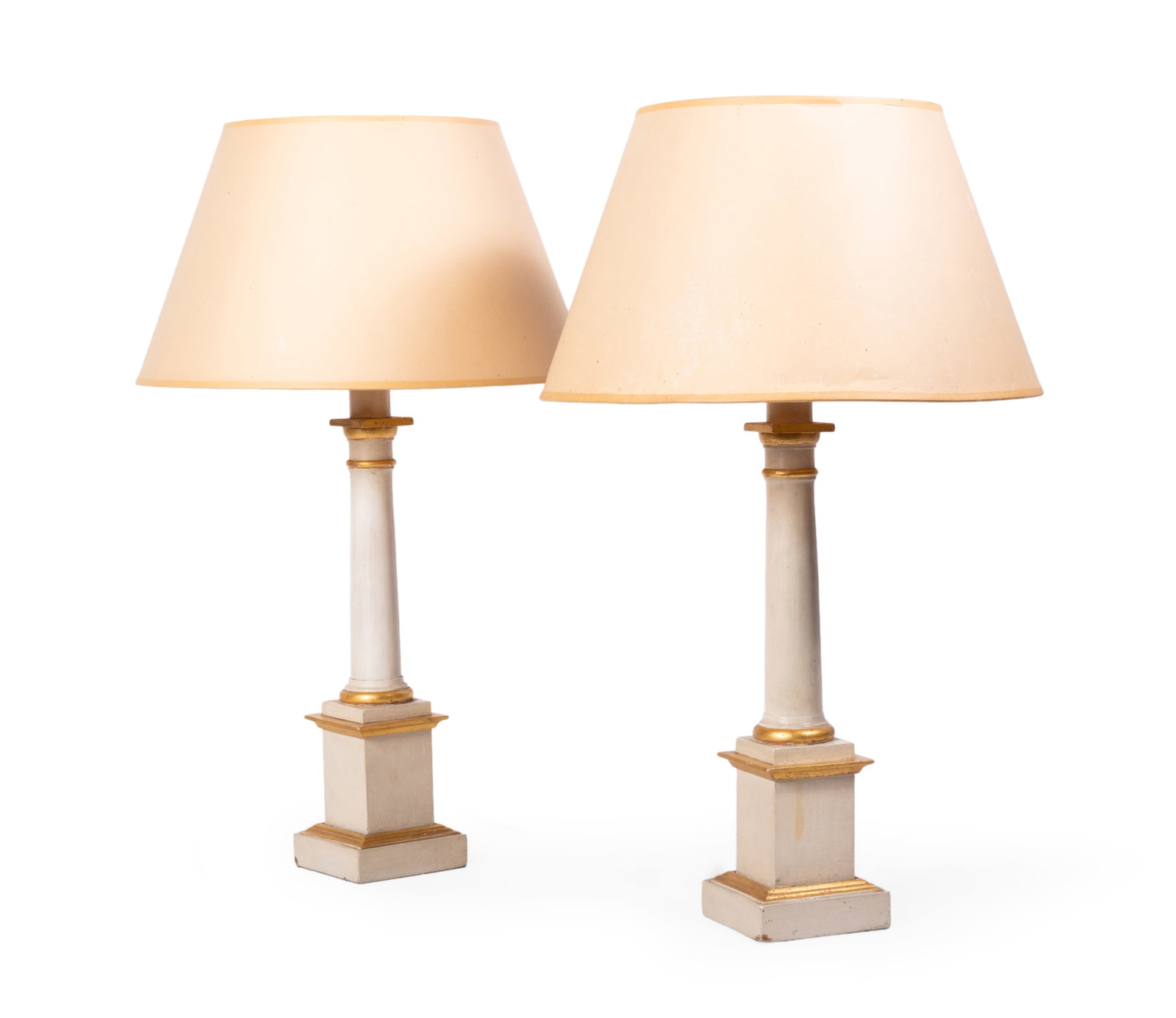 A PAIR OF CREAM AND GILT DECORATED TABLE LAMPS BY SIBYL COLEFAX & JOHN FOWLER, 20TH CENTURY: A PAIR OF CREAM AND GILT DECORATED TABLE LAMPS BY SIBYL COLEFAX & JOHN FOWLER, SECOND HALF 20TH CENTURY Fitted for electricity, with card shades 64cm high overall Provenance: A gift from John
