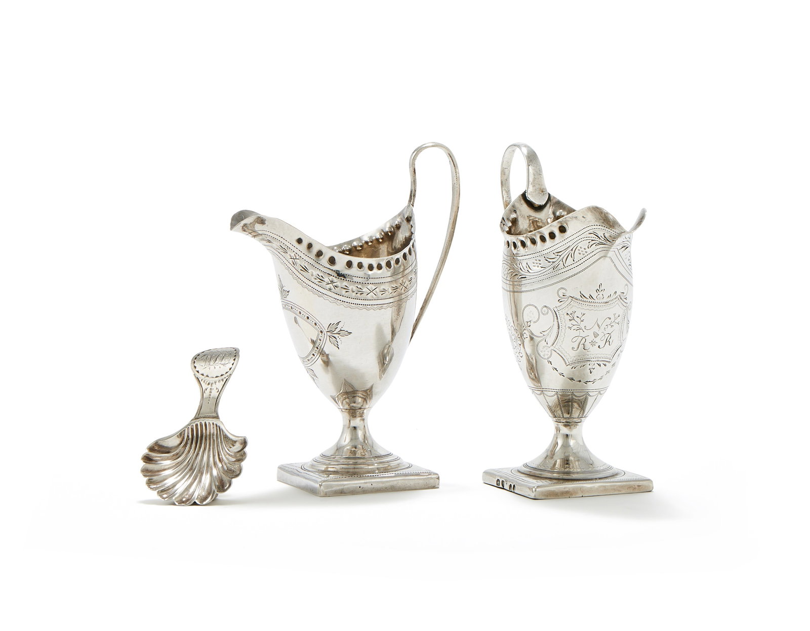 TWO GEORGE III HELMET SHAPED CREAM JUGS AND A CADDY SPOON BY PETER & ANN BATEMAN: A GEORGE III SILVER HELMET SHAPED CREAM JUGPETER & ANN BATEMAN, LONDON 1793With a high clip handle, a punched beaded border, engraved with an oval vacant reserve, the square foot engraved JG over JC 1