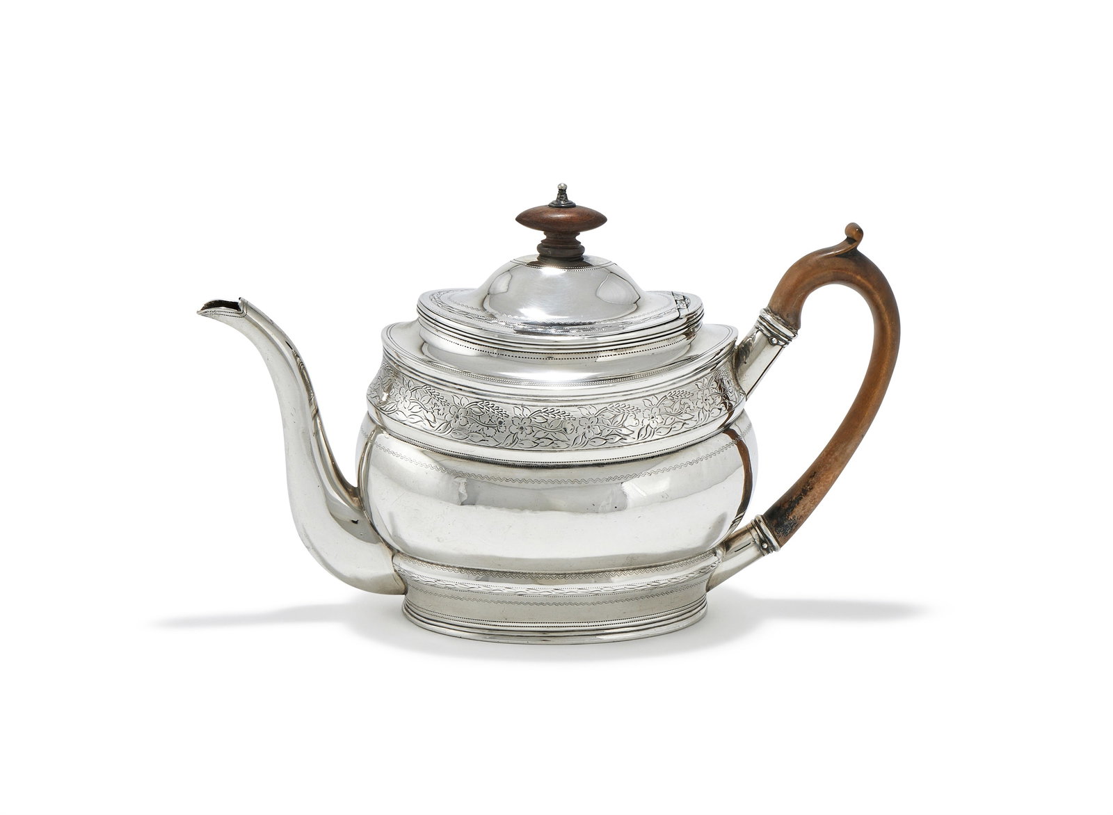 A GEORGE III SILVER OVAL TEAPOT, ROBERT HENNELL & SAMUEL HENNELL, LONDON 1803: A GEORGE III SILVER OVAL TEAPOTROBERT HENNELL & SAMUEL HENNELL, LONDON 1803With a wood oval finial and loop handle, engraved with floral and foliate bands27cm long461g (14.8 oz) gross