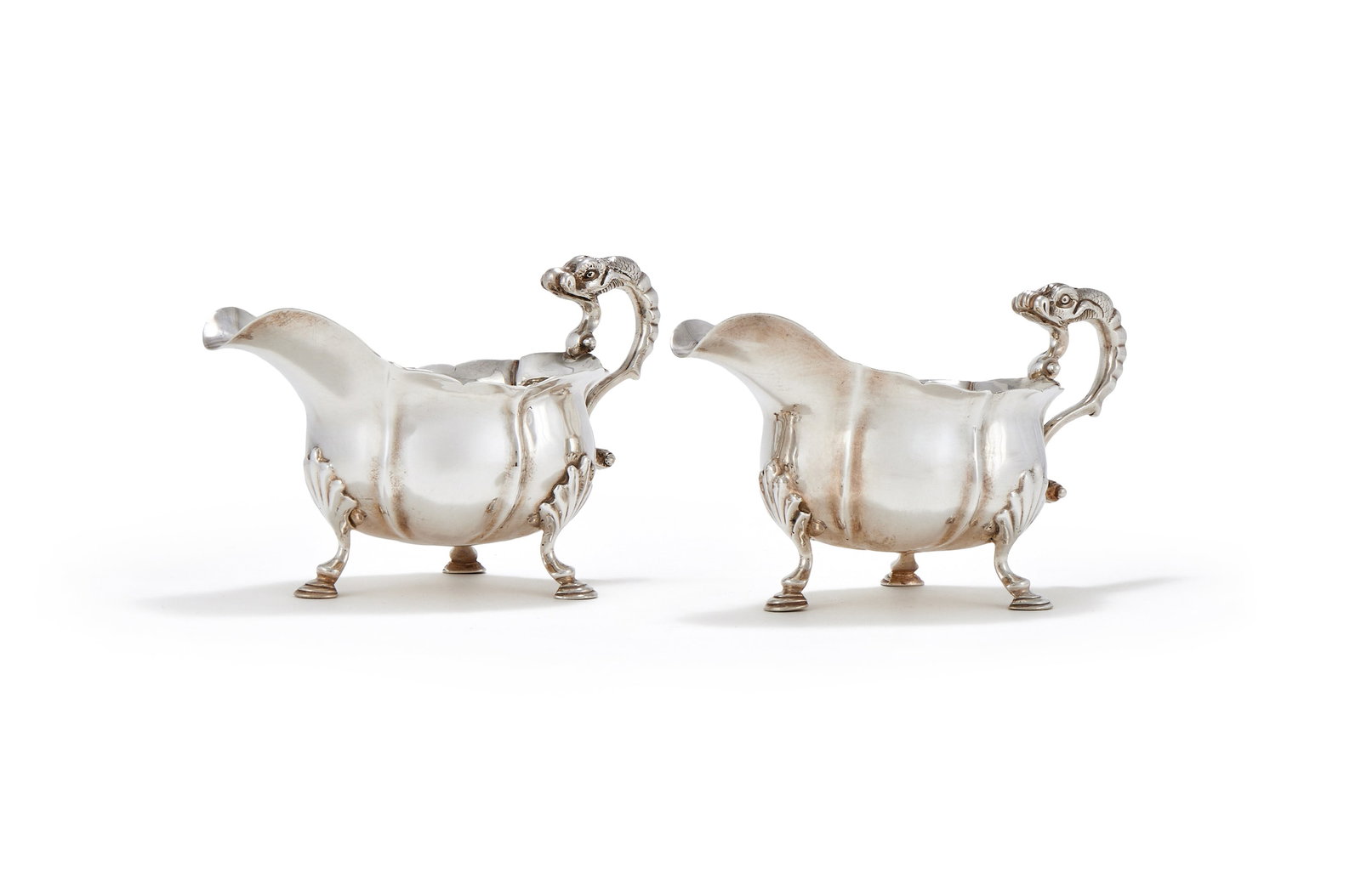 A PAIR OF GEORGE II SILVER SHAPED OVAL SAUCE BOATS, JOHN POLLOCK, LONDON 1746: A PAIR OF GEORGE II SILVER SHAPED OVAL SAUCE BOATSJOHN POLLOCK, LONDON 1746With shaped borders, dolphin scroll handles and on three shell and stepped pad feet19.5cm long830g (26.7 oz)